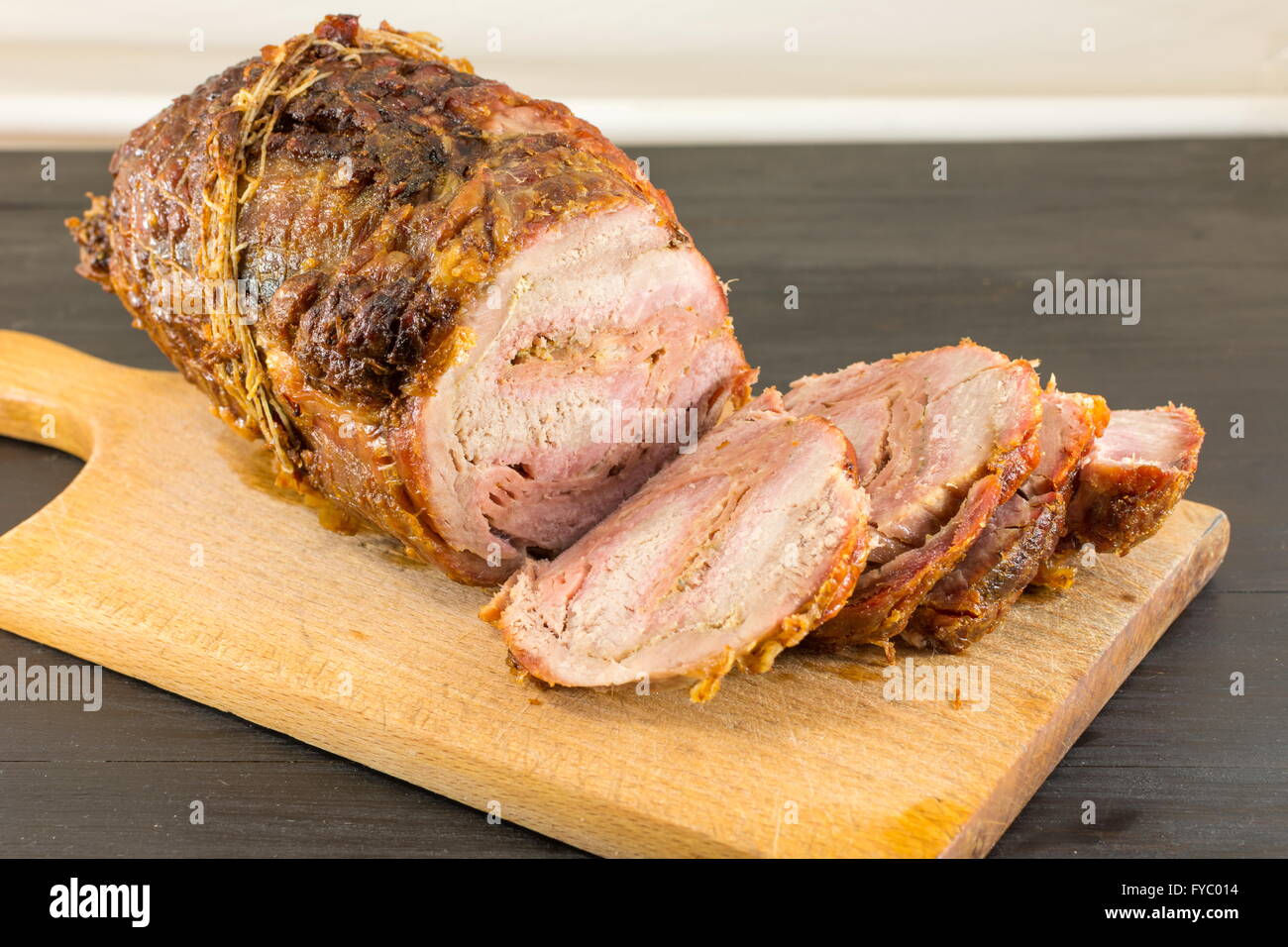 De porc rôti de viande sur une planche à découper sur un tableau noir Banque D'Images
