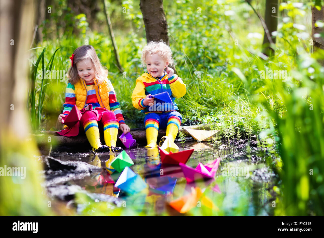 Les enfants jouent avec des bateaux en papier dans une petite rivière sur  un jour de printemps ensoleillé. Les enfants jouent à la découverte de la  nature Photo Stock - Alamy