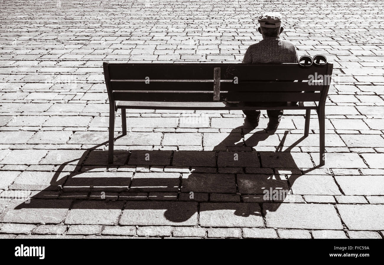 Vieil homme avec des béquilles assis sur son fauteuil avec vue sur la mer. Banque D'Images