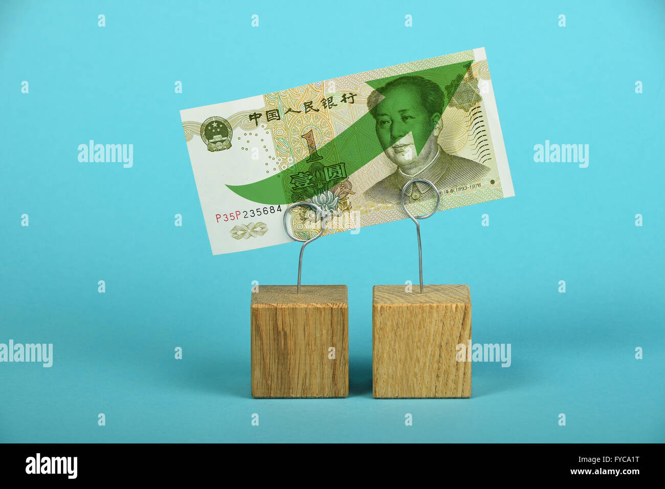 La croissance et l'appui de l'économie chinoise et yuan yuan, un billet suspect avec flèche verte sur deux supports sur fond bleu Banque D'Images