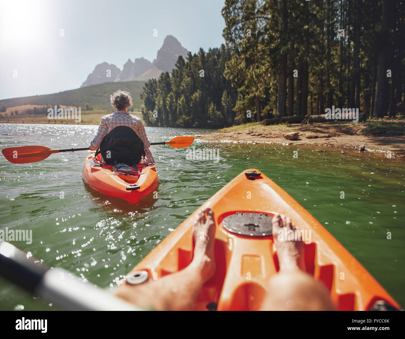 Couple canoë dans les lac sur une journée d'été. L'homme et la femme dans deux différents kayaks dans le lac sur une journée ensoleillée. Banque D'Images