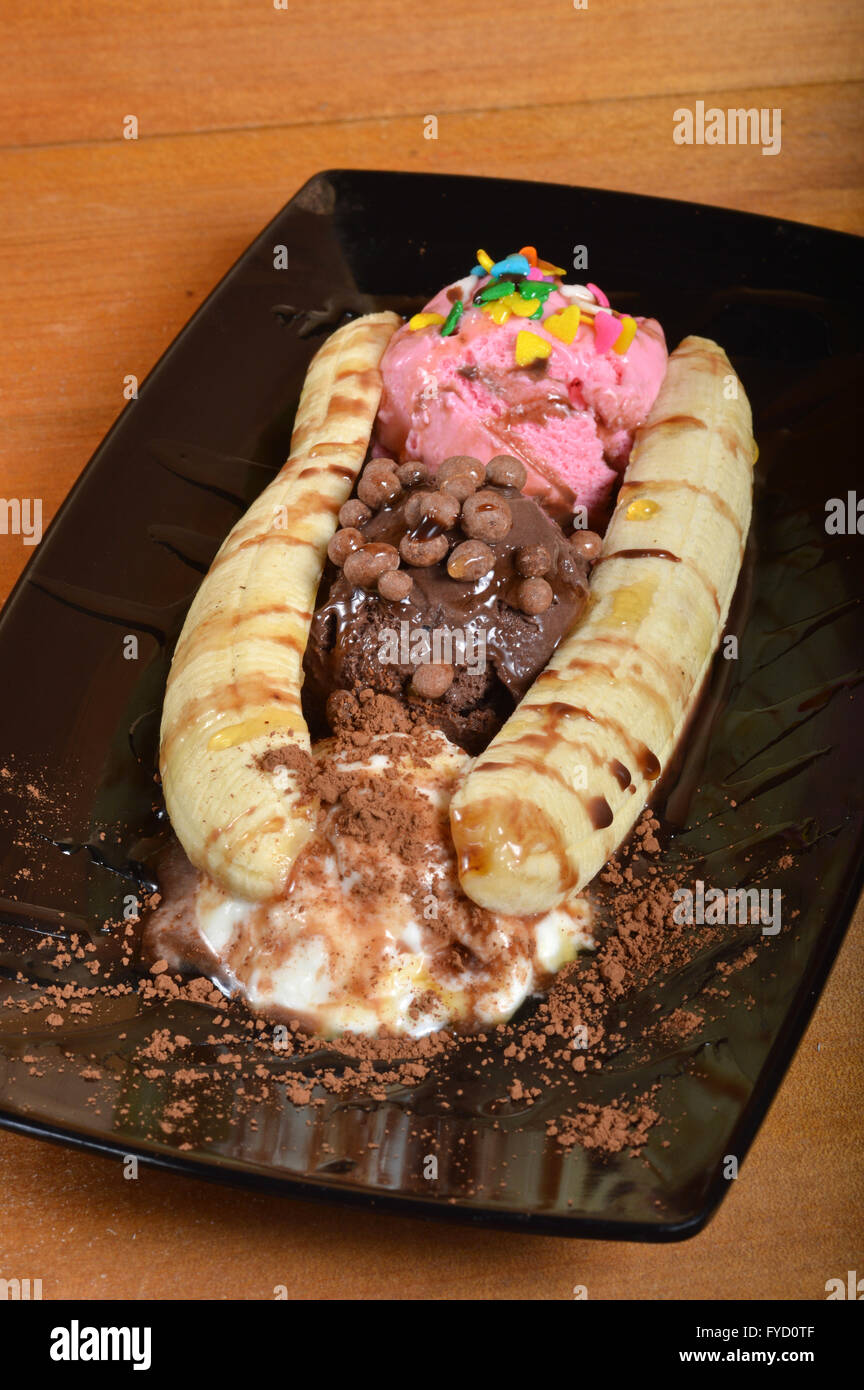 Banana split avec de la crème glacée sur planche de bois Banque D'Images