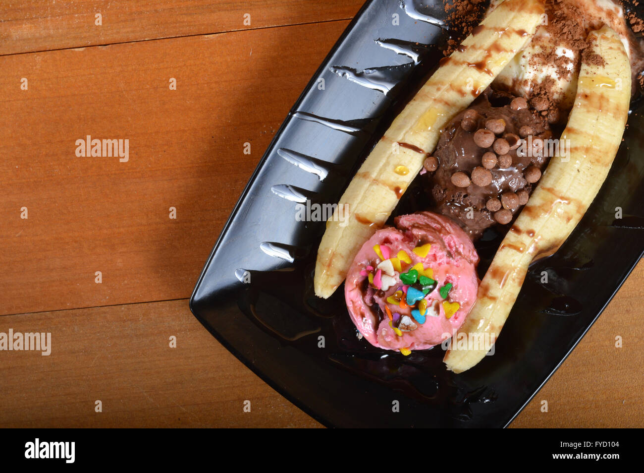 Banana split avec de la crème glacée sur planche de bois Banque D'Images