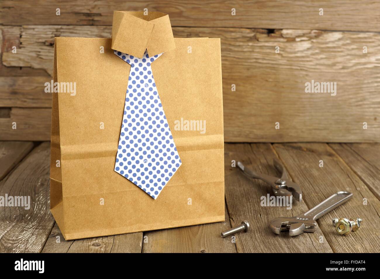 Des pères chemise et cravate fait main sac-cadeau avec des outils sur un fond de bois Banque D'Images