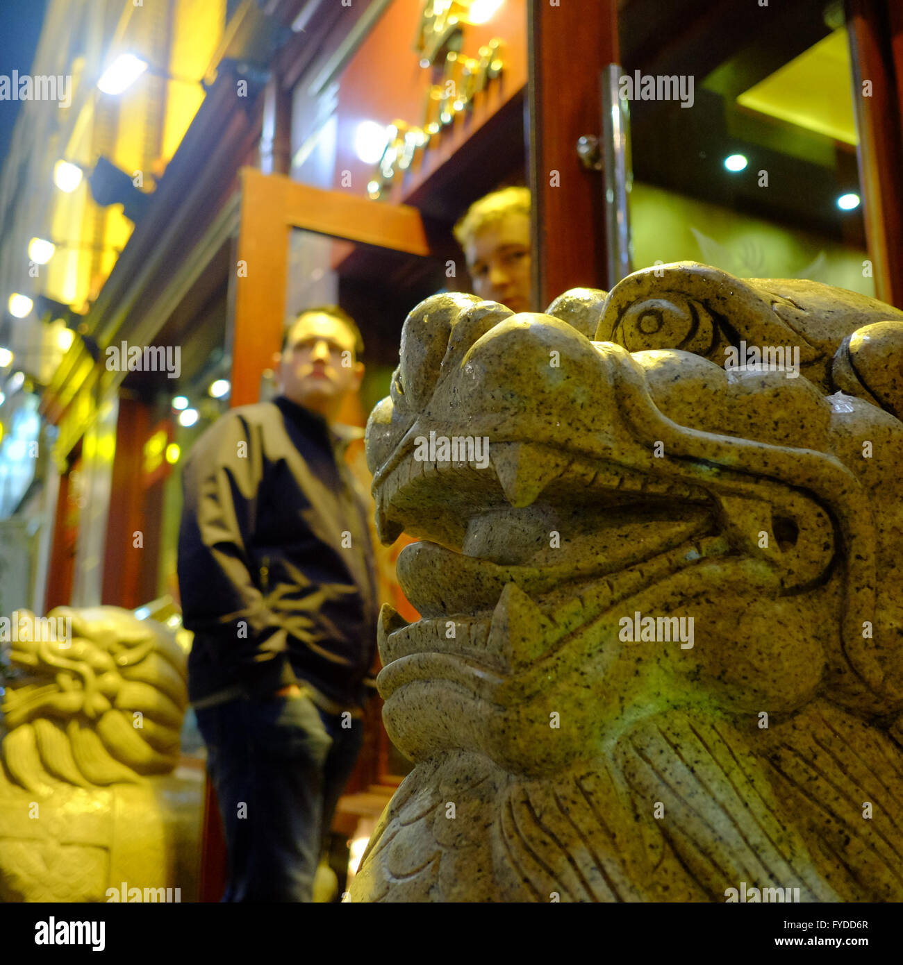 Sculptures Lion chinois au restaurant avec deux hommes debout dans l'entrée du Caucase dans Chinatown, Soho, Londres Banque D'Images