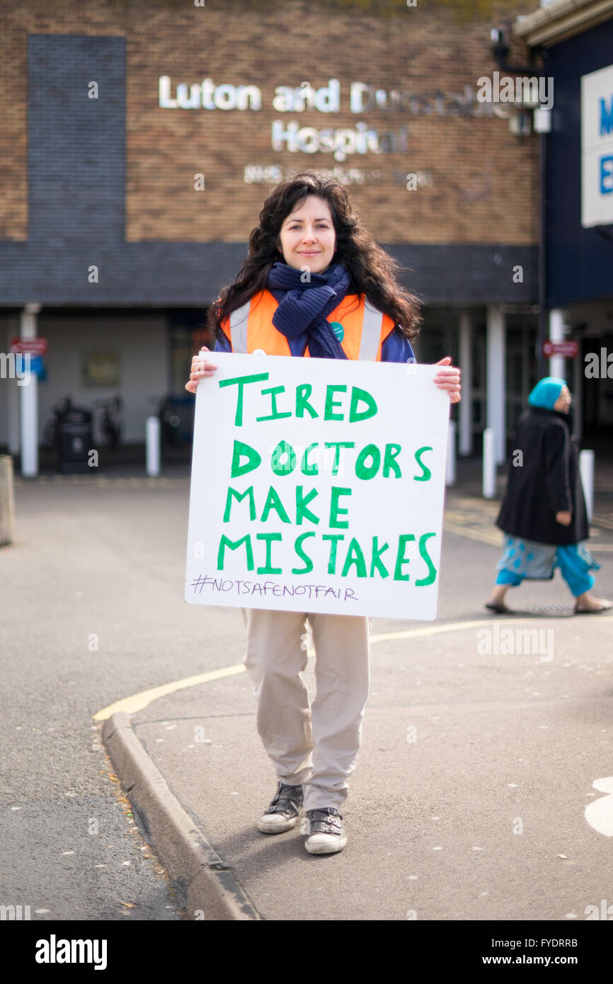 Luton, Royaume-Uni, 26 avril 2016. Trouver un médecin Junior Sammy Rostampour tient une pancarte qui dit "fatigué" les médecins font des erreurs en dehors de l'hôpital Luton and Dunstable. Dr Rostampour a déclaré : "Je suis en fait un temps partie stagiaire, j'ai deux enfants. Je m'entraîne depuis longtemps et à plusieurs niveaux qu'il va m'affecter. C'est très discriminatoire envers les femmes et flexible des stagiaires. Moins de travail/vie personnelle - j'ai déjà un travail en quatre fins de semaine de toute façon. Mon mari est médecin donc il est très difficile (avec enfants) déjà. Il va le rendre vraiment intenable." Crédit : Philip Kirk/Alamy Live News Banque D'Images