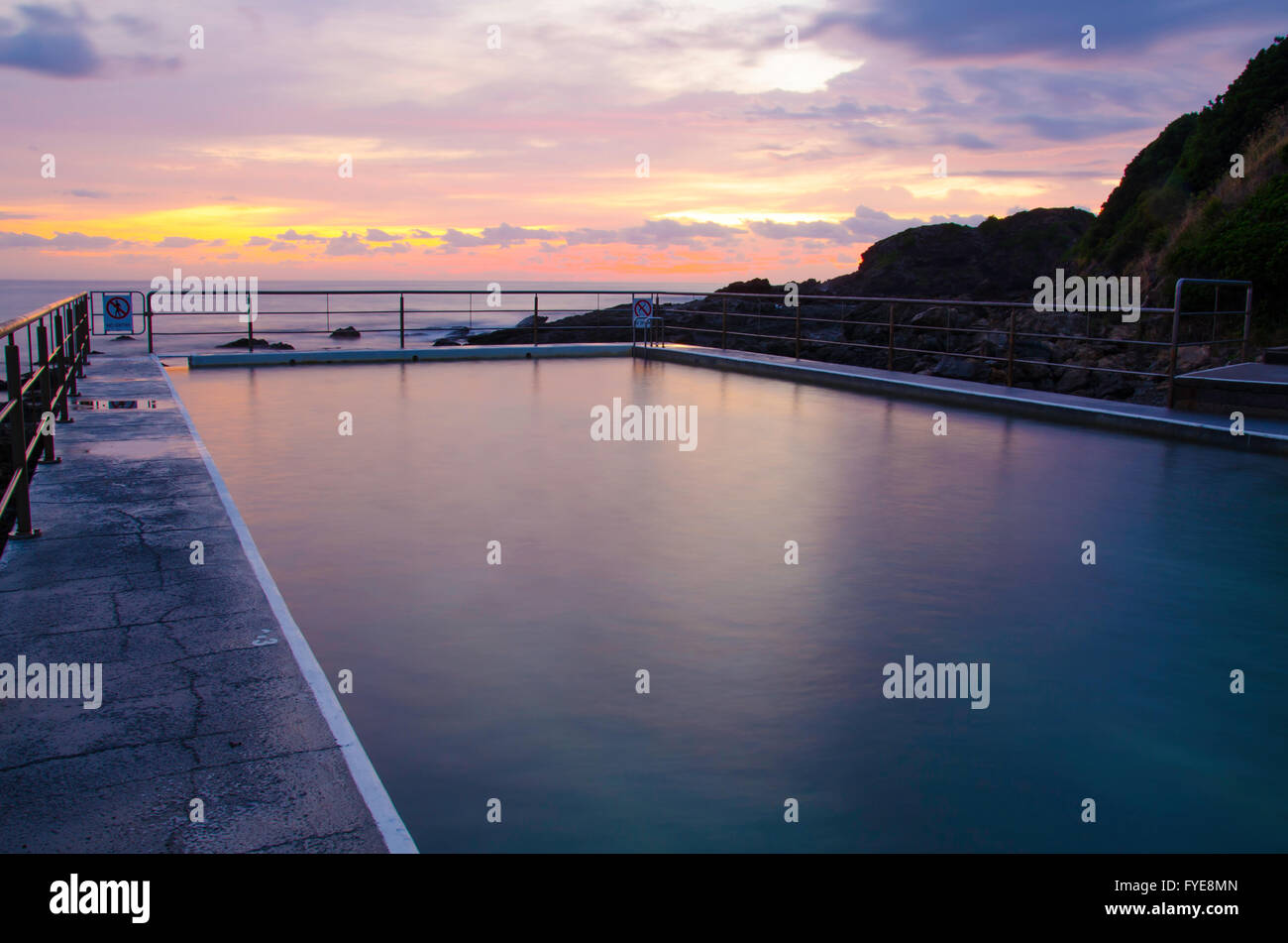 Nagerez dans une piscine non utilisée sur l'océan à Black Head Beach, Nouvelle-Galles du Sud, Australie Banque D'Images