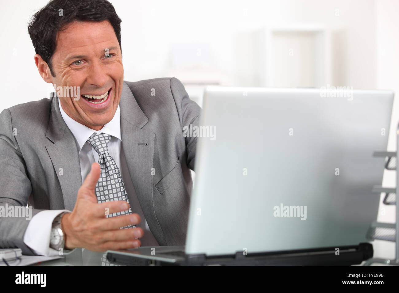 Homme rire hystériquement à son ordinateur portable Banque D'Images