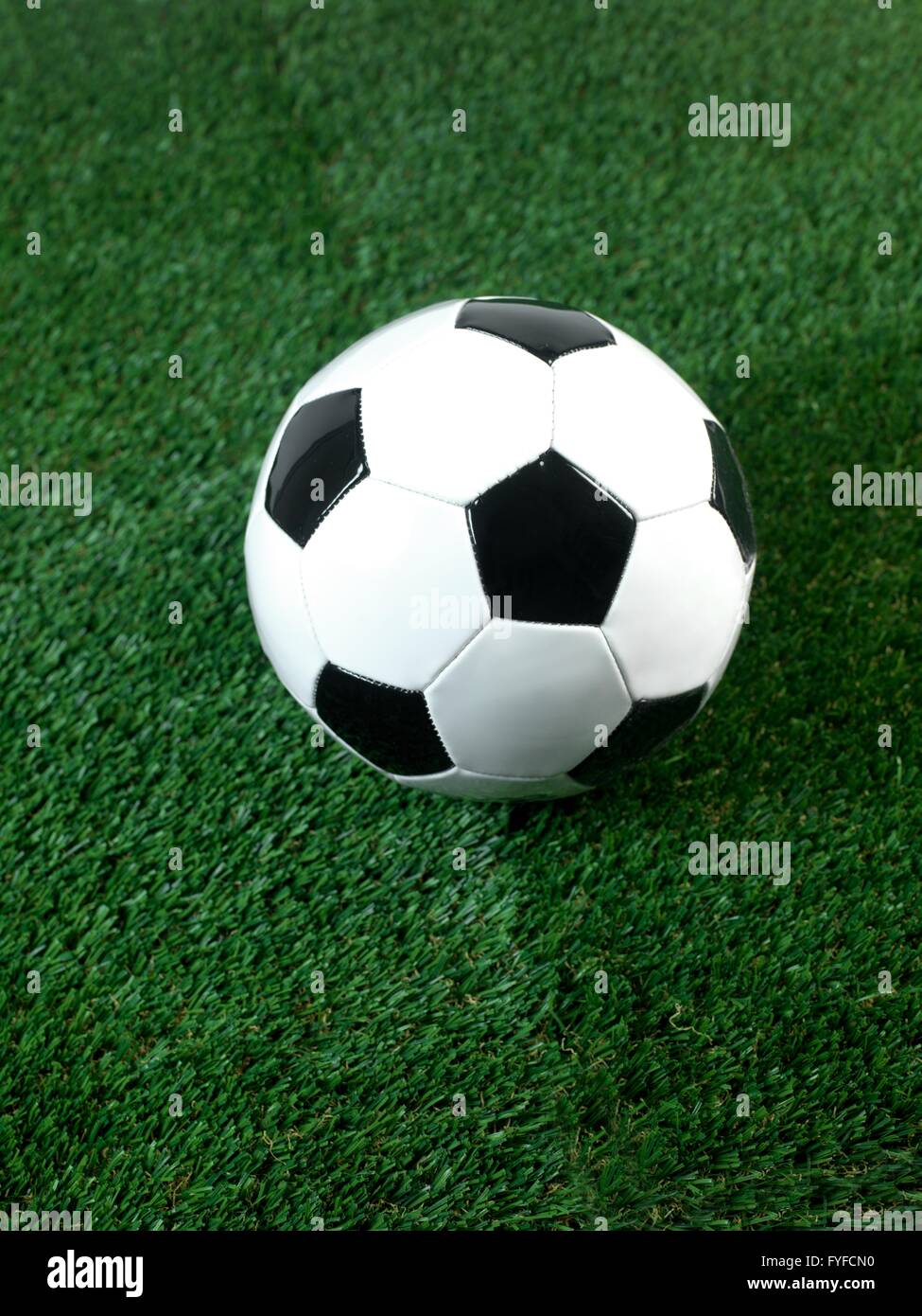 Les ballons de football noir et blanc isolé sur le gazon artificiel Banque D'Images