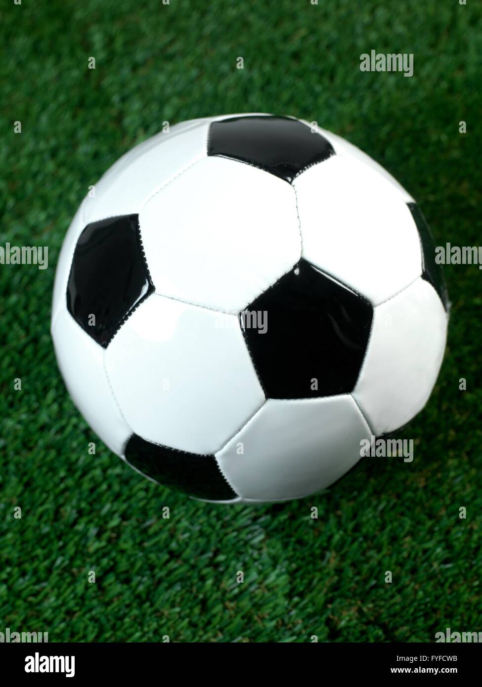Les ballons de football noir et blanc isolé sur le gazon artificiel Banque D'Images
