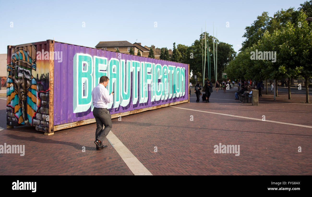 Londres, Angleterre - 21 juillet 2015 : un piéton passe devant un conteneur d'expédition avec le mot "beautification" peint sur elle en Br Banque D'Images