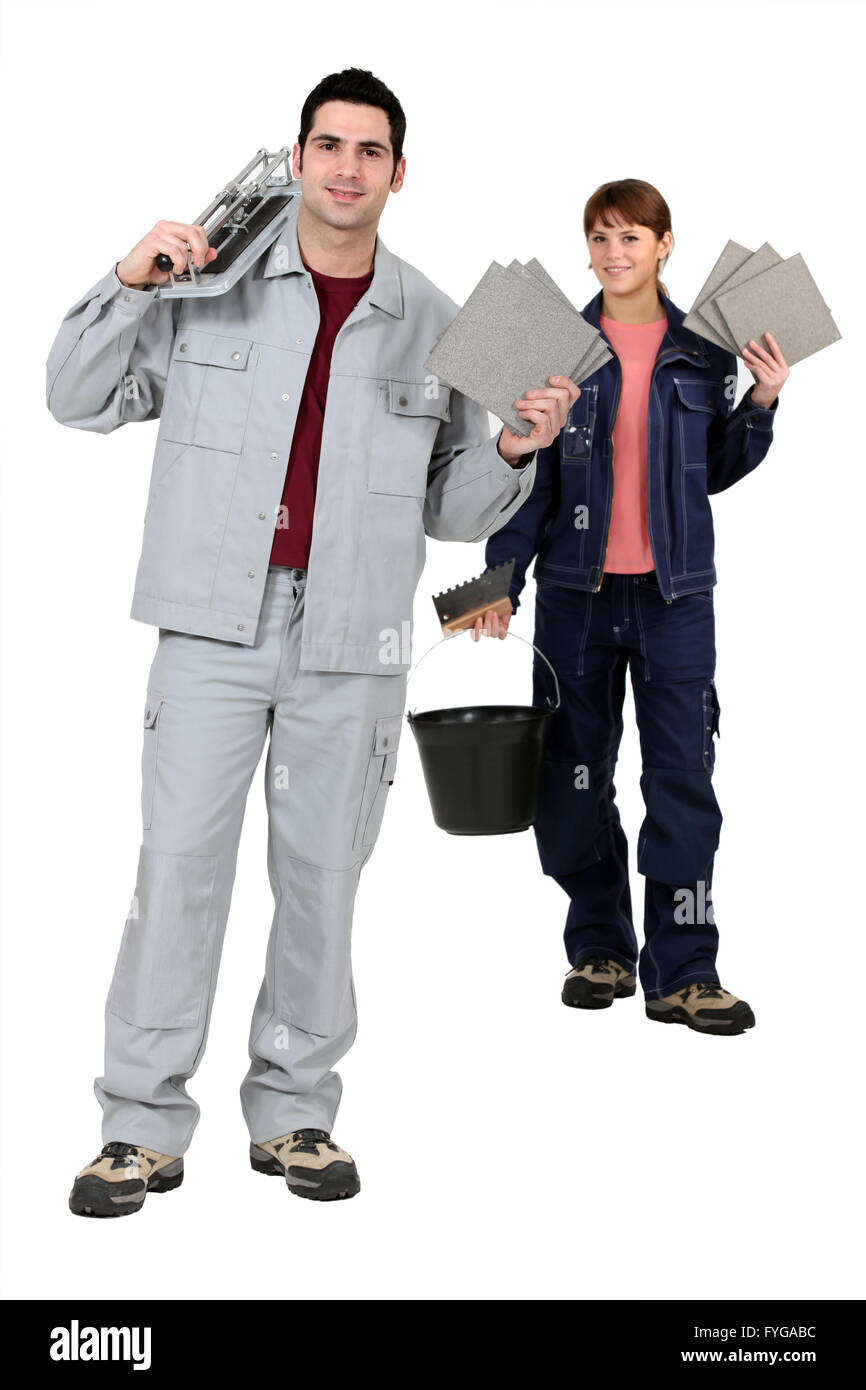 Les monteurs de tuile holding up leurs outils et fournitures de construction Banque D'Images