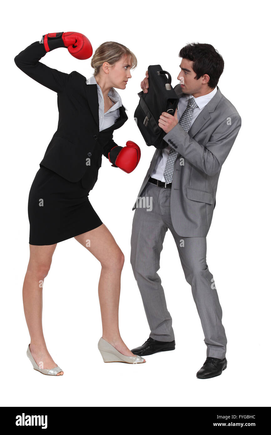 Businesswoman menace collègue masculin avec des gants de boxe Banque D'Images