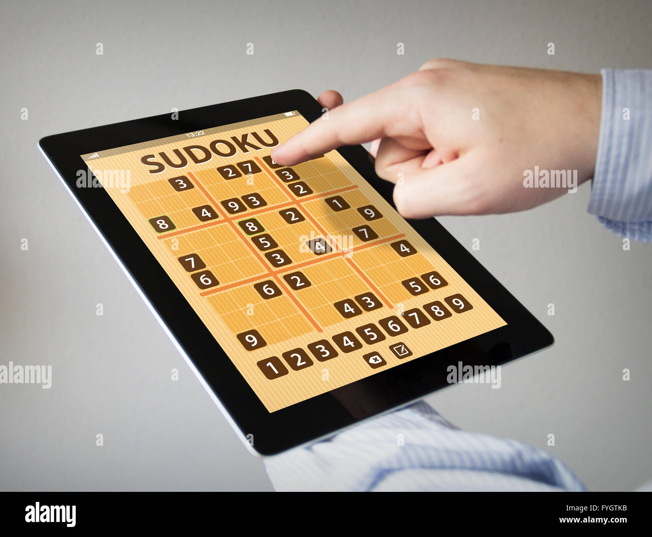 Les mains à l'écran tactile Tablet avec application jeu sudoku Banque D'Images