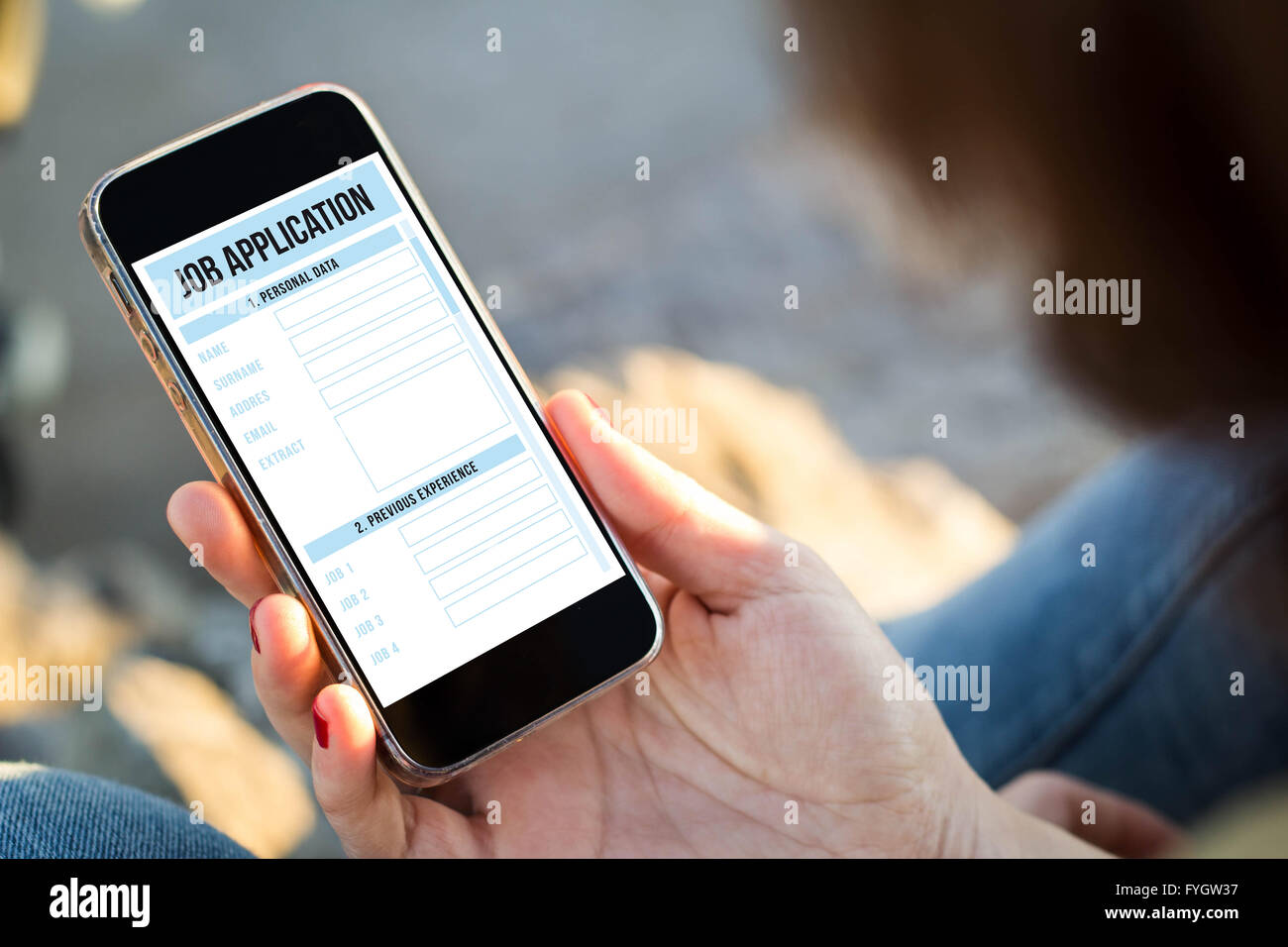 Close-up view of young woman holding un smartphone avec les demandes d'emploi à l'écran. Tous les graphiques de l'écran sont constitués. Banque D'Images