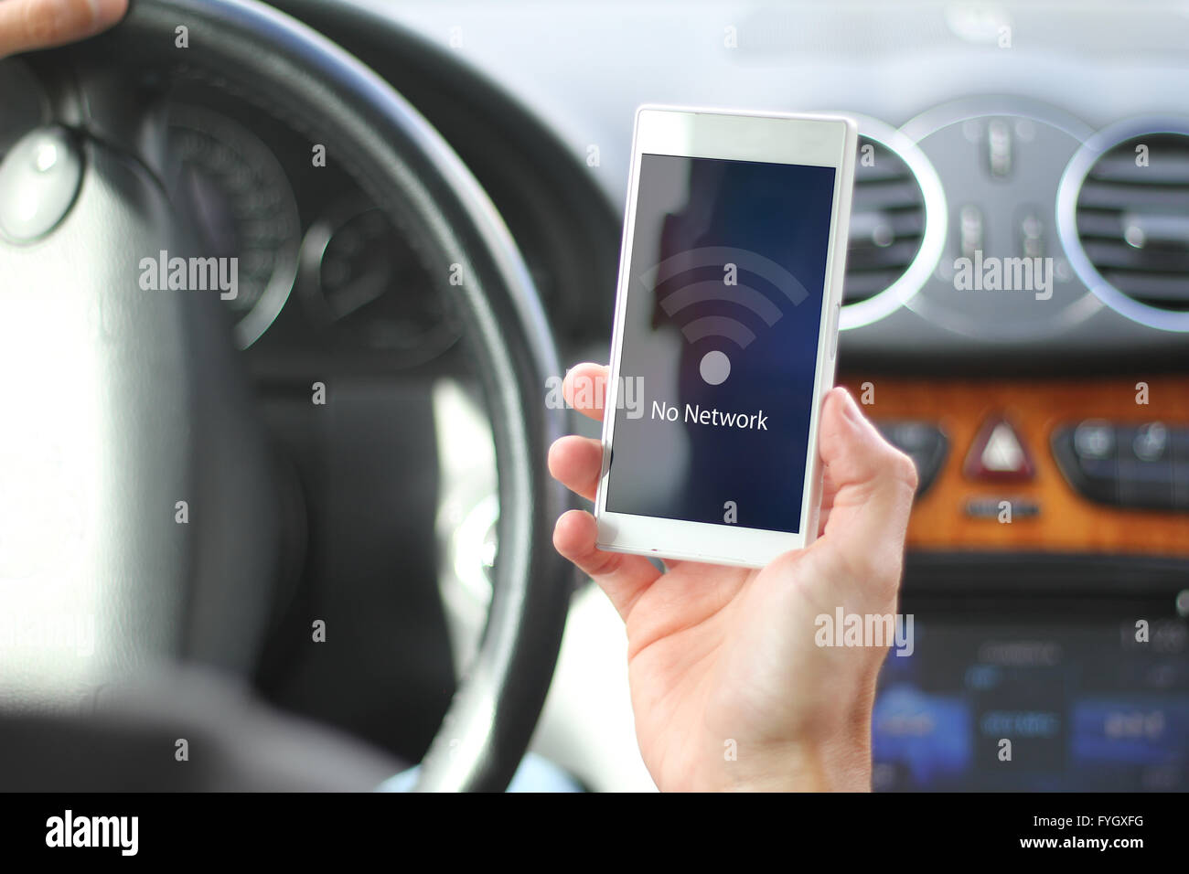 Risques de conduite concept : Conducteur titulaire du smartphone avec aucun réseau à l'écran. Tous les graphiques de l'écran sont constitués. Banque D'Images