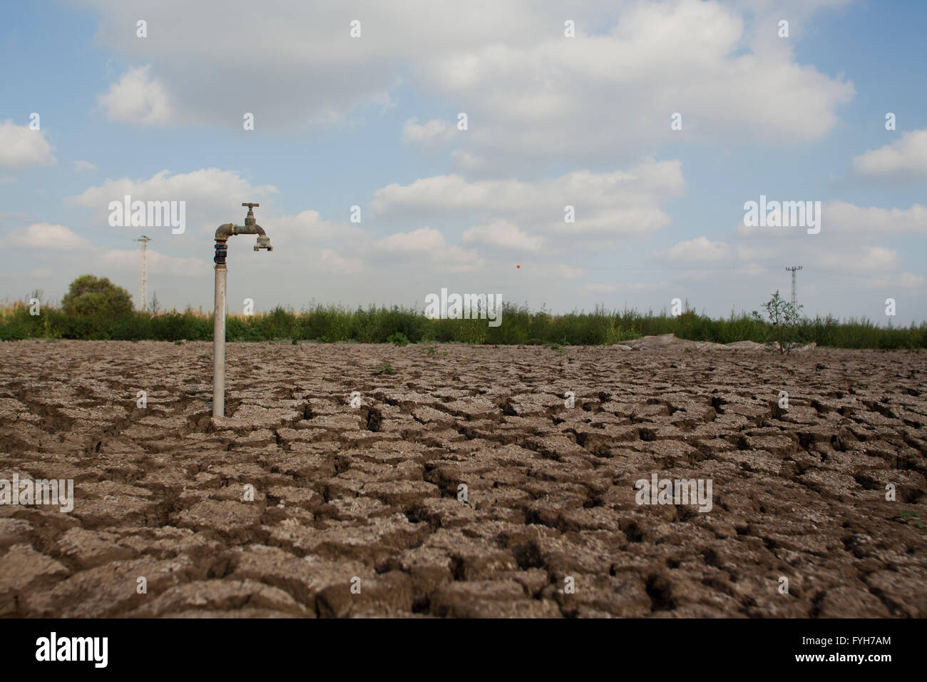 Concept de l'environnement, la pénurie d'eau et de la sécheresse de la boue craquelée à sec avec un robinet d'eau Banque D'Images