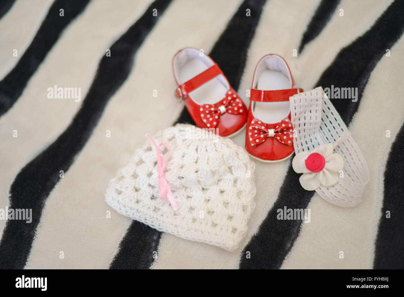 Chaussures rouges, le chapeau et les filles bandeau s'assit sur le lit Banque D'Images