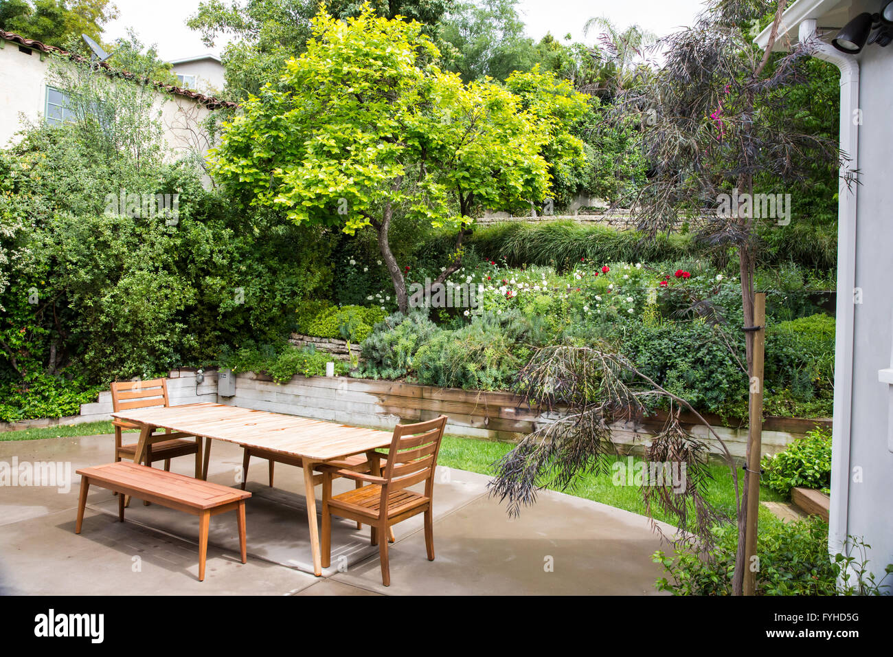 Une table de pique-nique en bois attend que les invités dans un jardin paysagé Banque D'Images