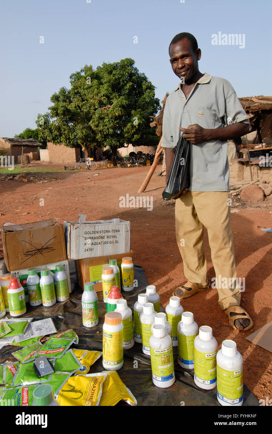 Le Burkina Faso, vendeur de rue vendent des pesticides chimiques pour le coton et d'autres culture à l'agriculteur au marché du village , paysan peuvent souvent pas lu les instructions et en danger leur santé et l'environnement avec l'utilisation incorrecte - agriculture pesticides antiparasitaires | [ Copyright (c) Joe Banque D'Images