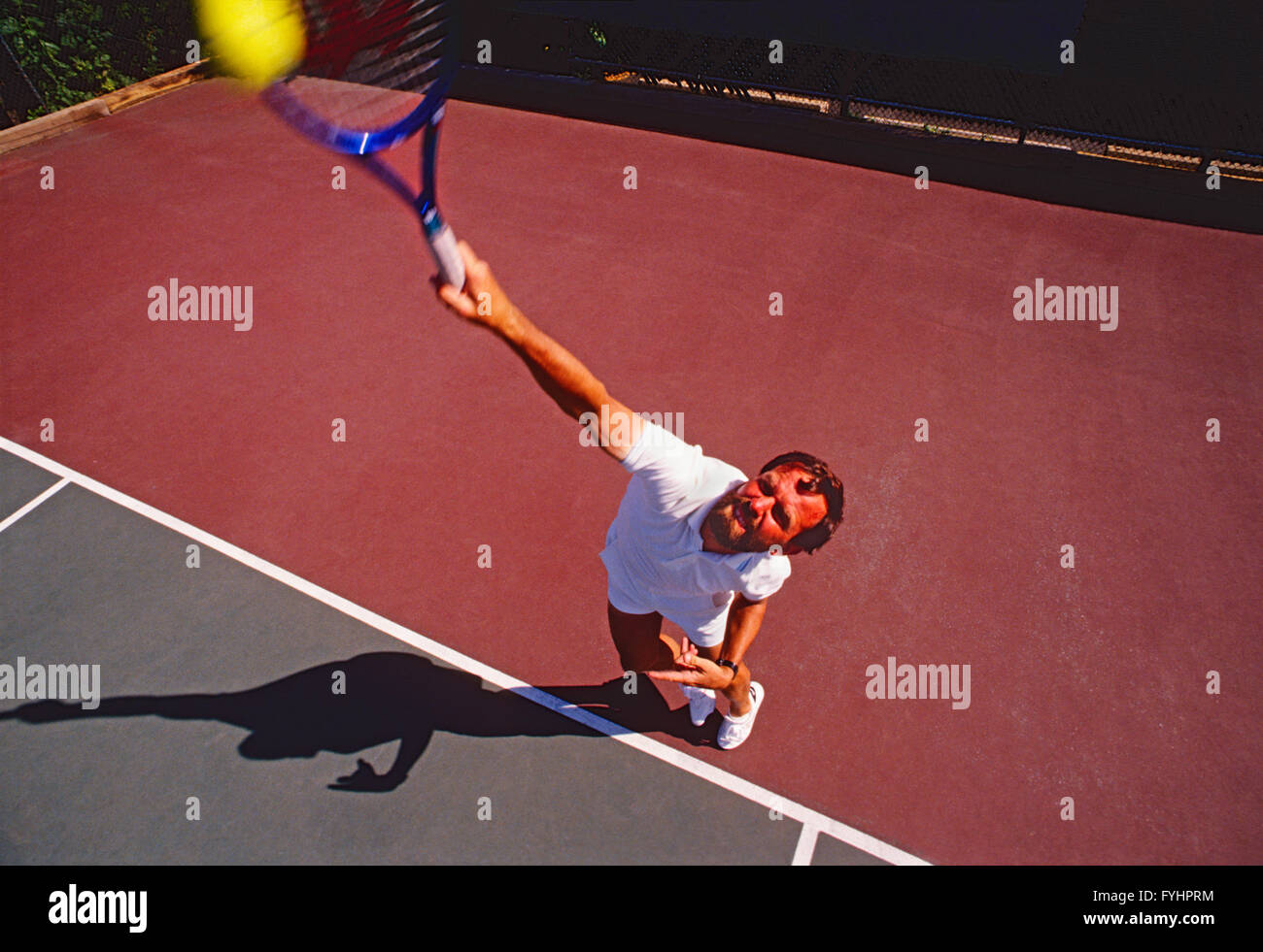 Vue supérieure de l'homme joueur de tennis frapper la balle avec une raquette Banque D'Images