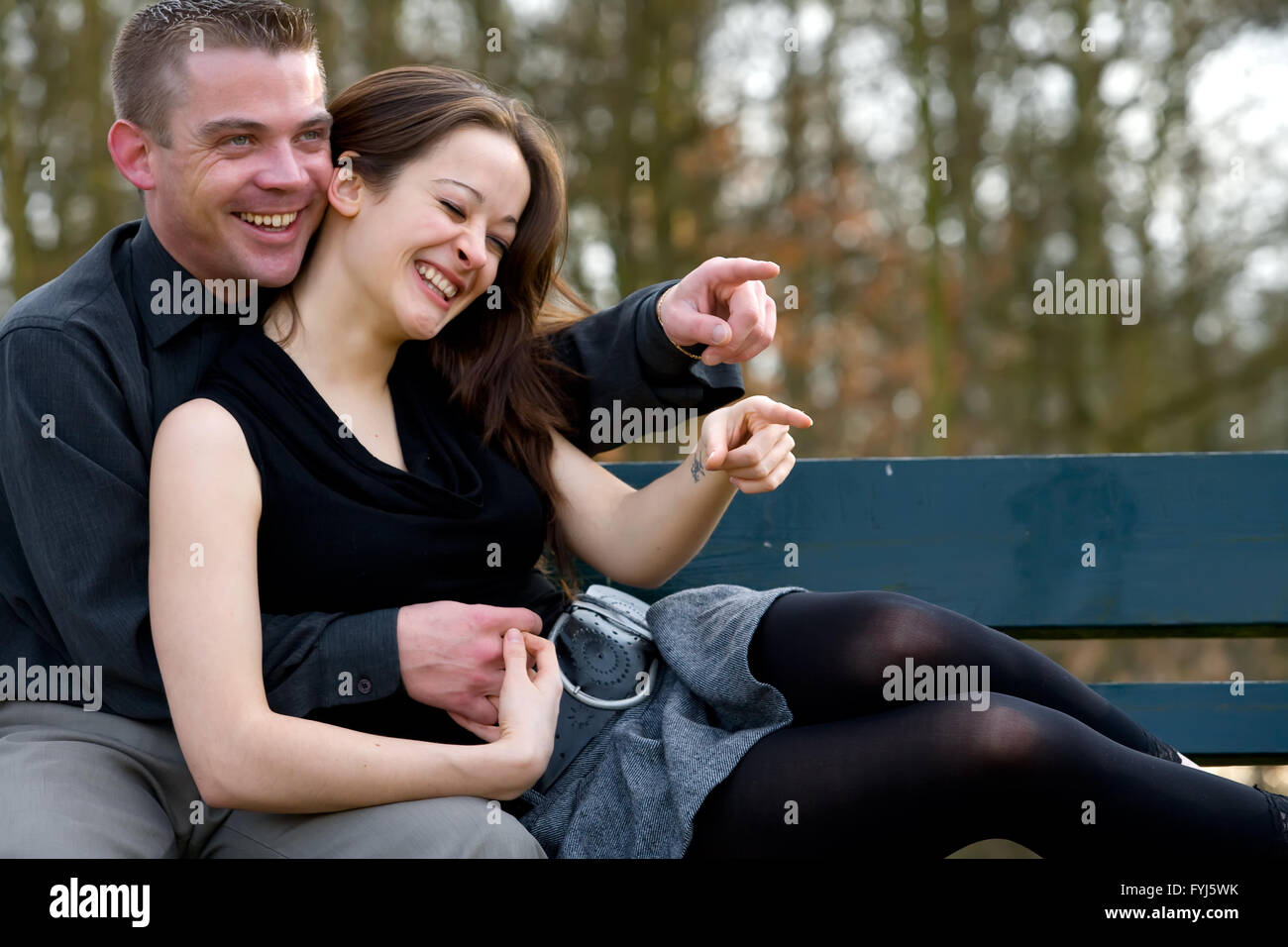Jeune couple sur un banc s'amusant Banque D'Images