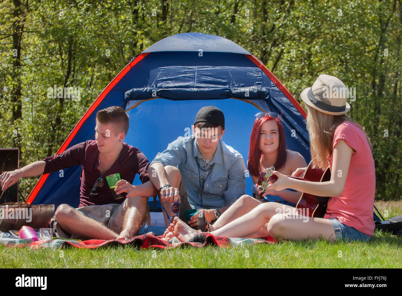 Les jeunes sur un camping barbecue Banque D'Images