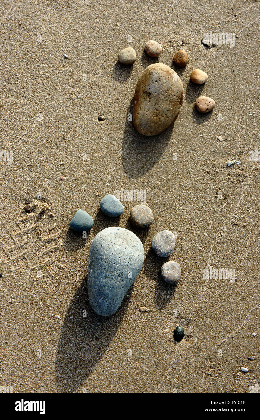 Groupe de pied par galet sur fond de sable, une notion de pierre avec des couleurs jaune, sur la plage, super produit art Banque D'Images