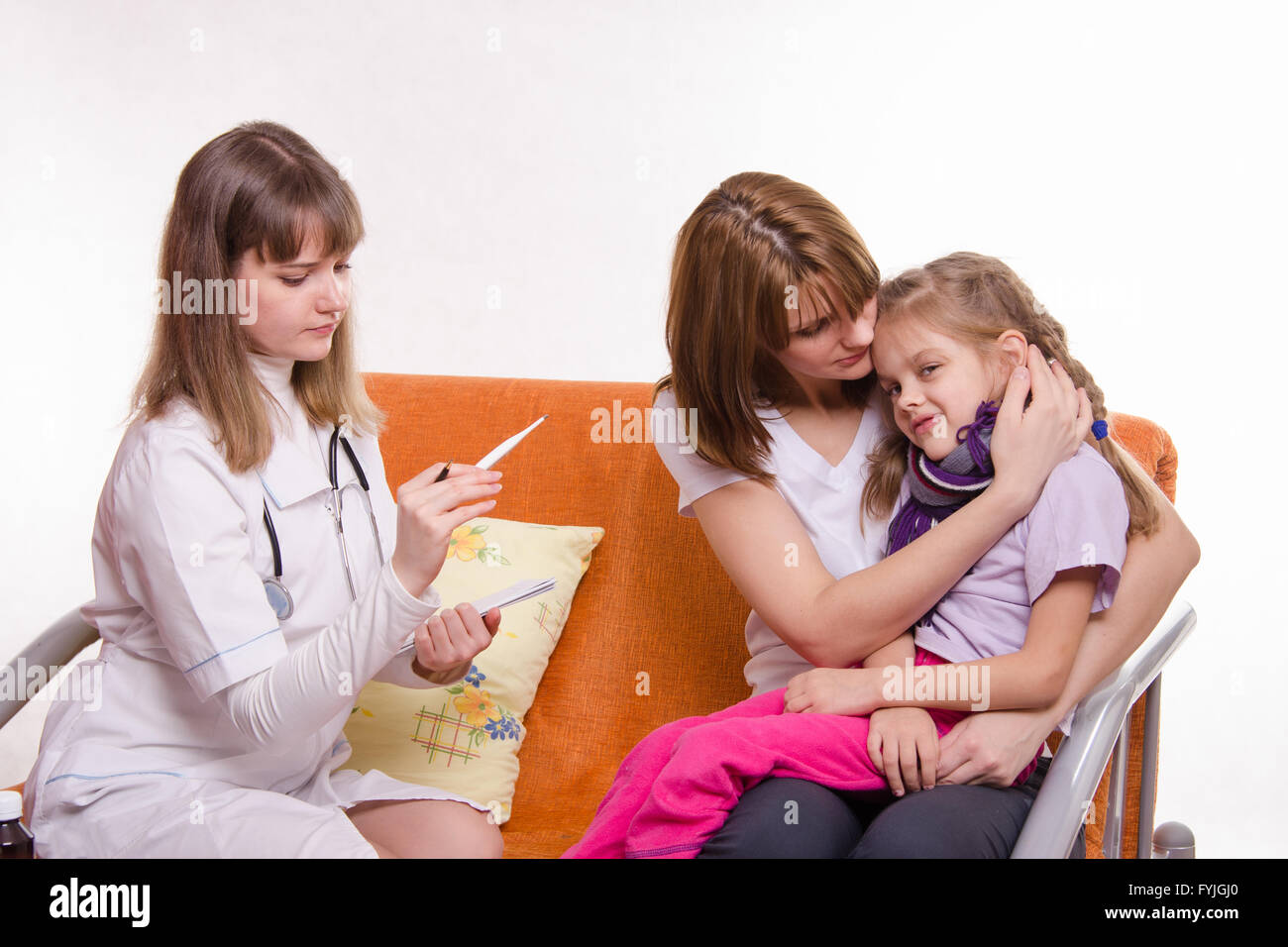 Médecin regarde la température sur un thermomètre sick girl et le confort de sa mère Banque D'Images