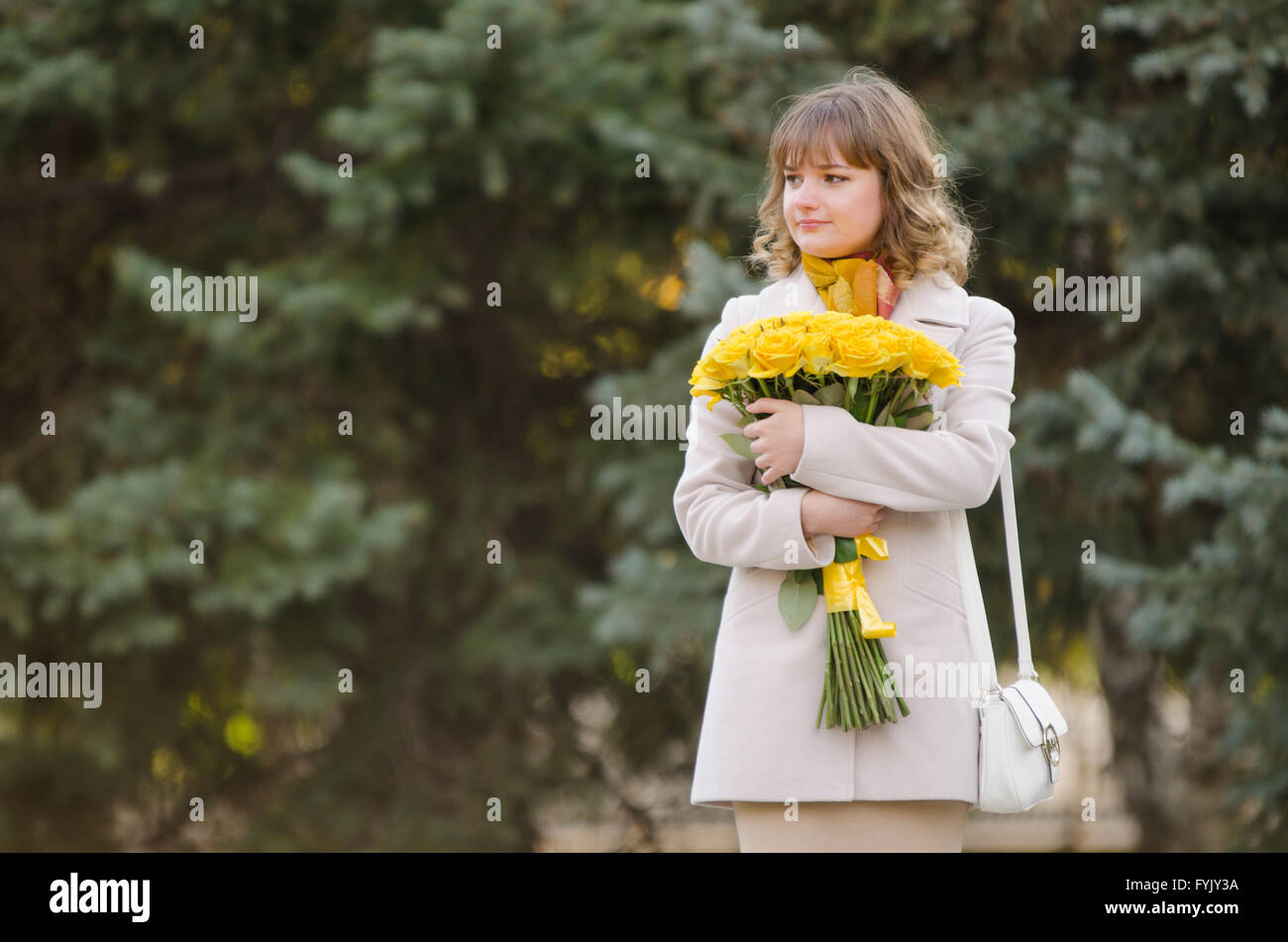 Jolie petite fille avec des roses jaunes en attente de nomination Banque D'Images