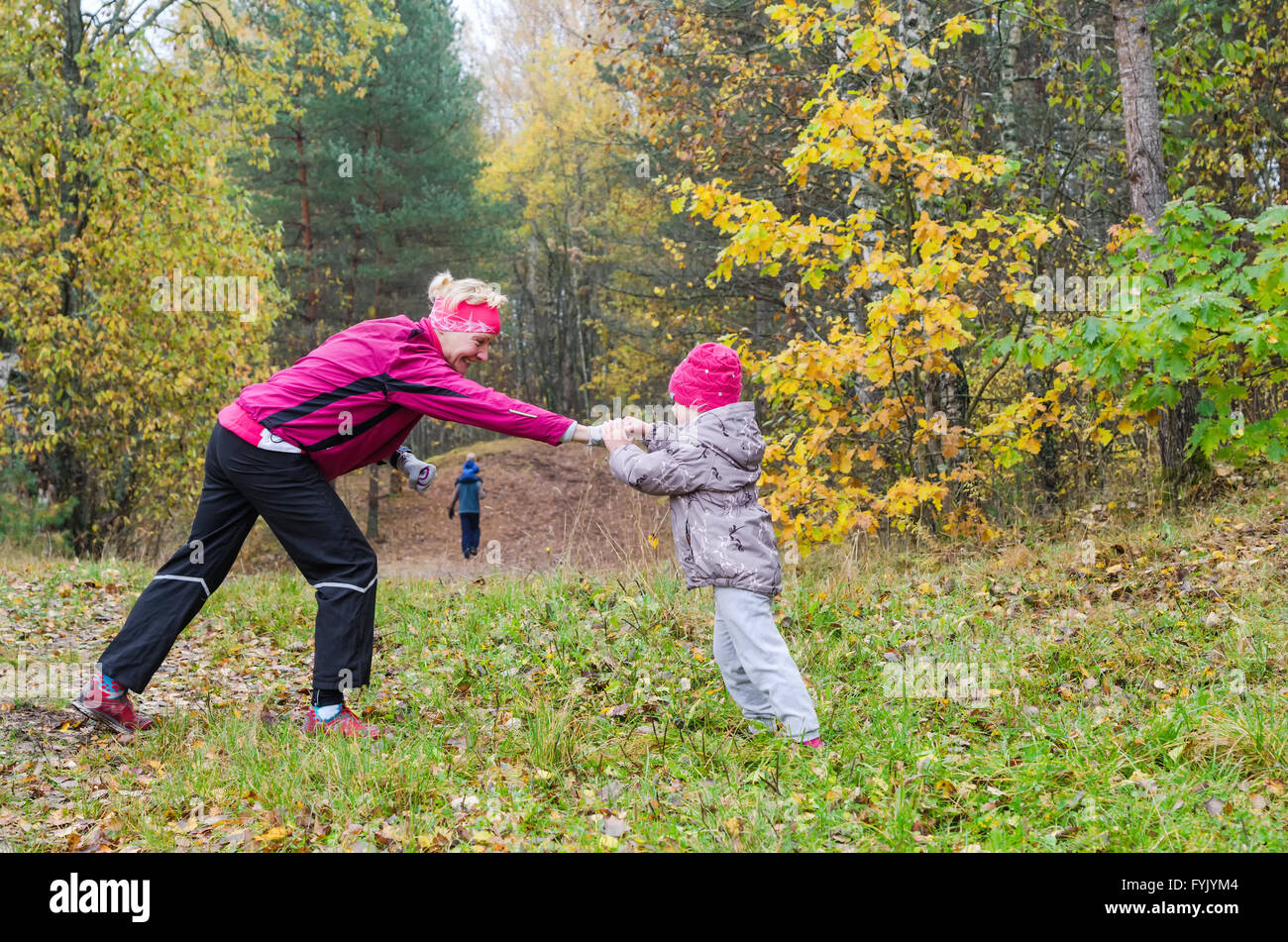 Femme avec fille faisant de l'aérobic dans le parc en automne Banque D'Images