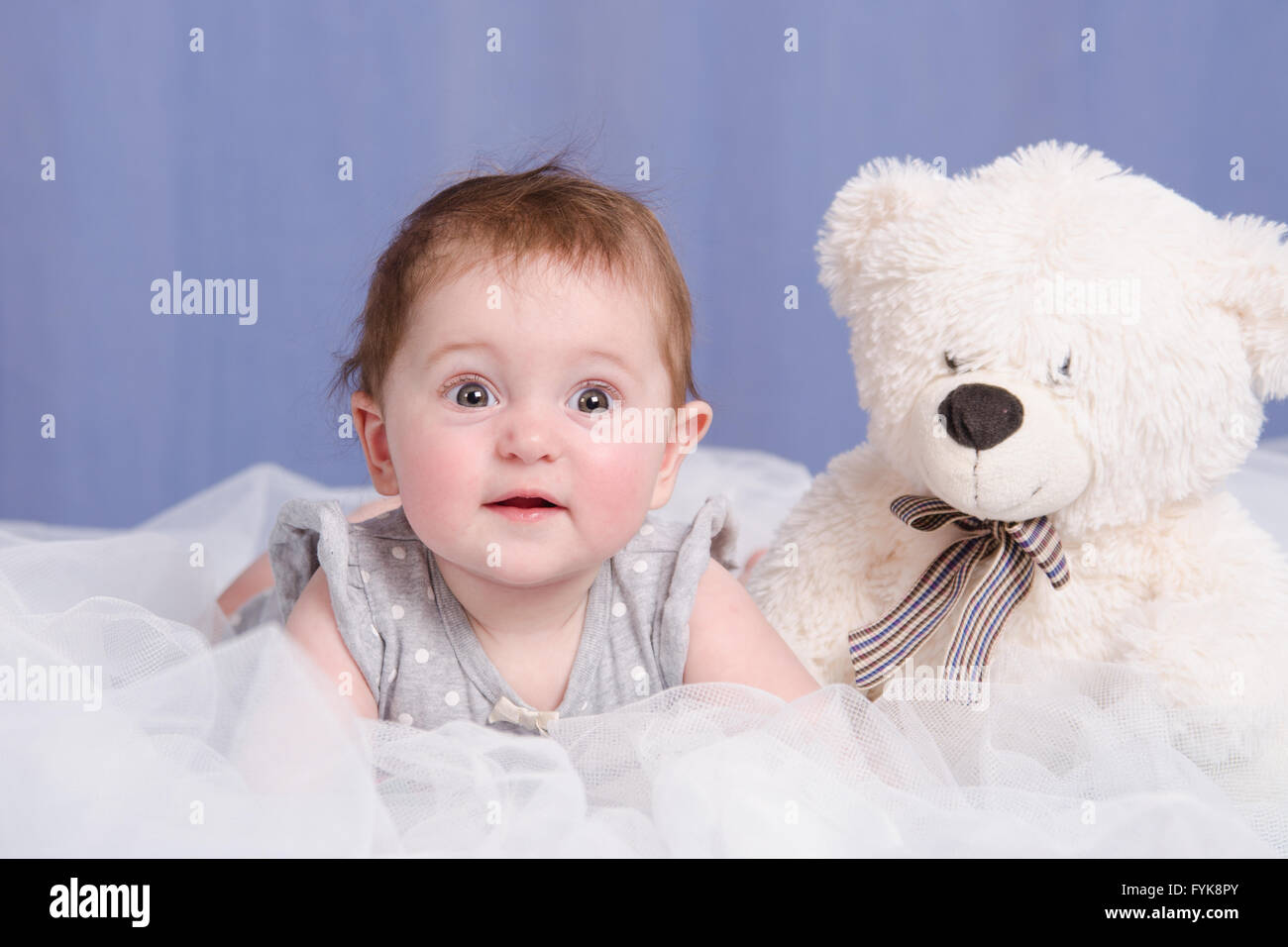 Six mois baby girl with teddy bear lying on couch Banque D'Images