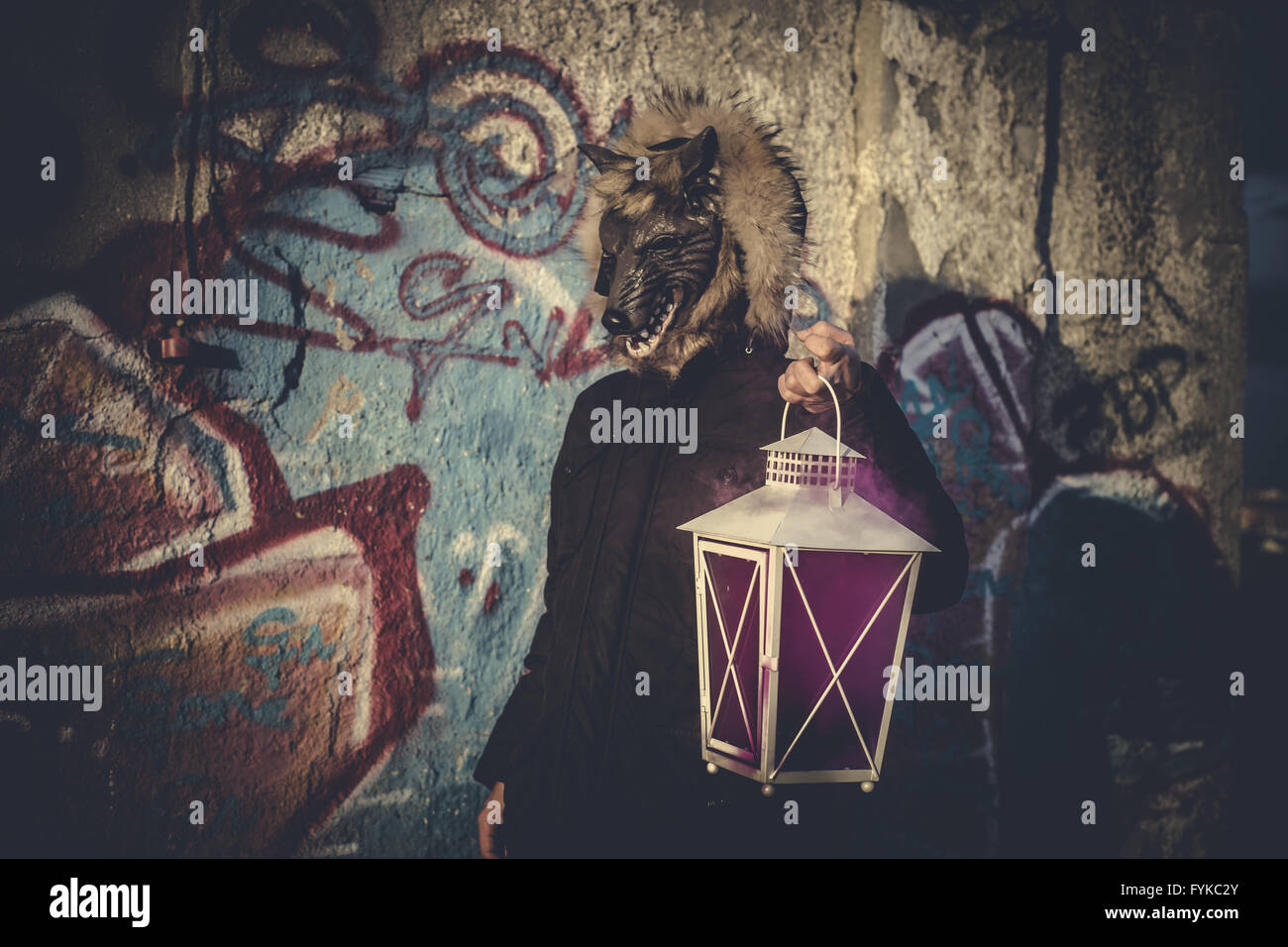 L'homme avec masque loup et lampe avec la fumée de couleur Banque D'Images