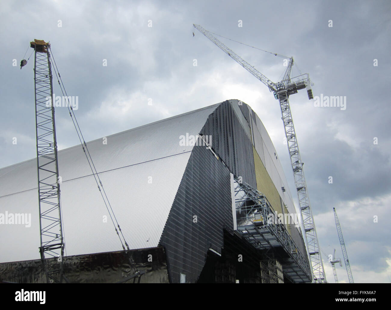 Une grue domine le confinement de sécurité en acier inoxydable cercueil qui mesure plus de 100 mètres de hauteur, pesant 30 000 tonnes à Tchernobyl, en Ukraine, 22 avril 2016. Le cercueil sera positionnée au-dessus du réacteur nucléaire endommagé nr. 4 de la centrale nucléaire de Tchernobyl de 2017, pour les 100 prochaines années. Photo : Andreas Stein/dpa Banque D'Images