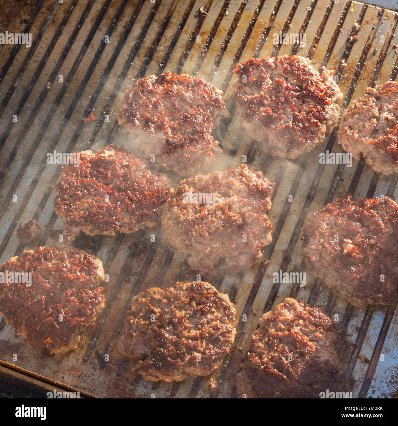 Étant des burgers de bœuf grillées sur food grill. Banque D'Images