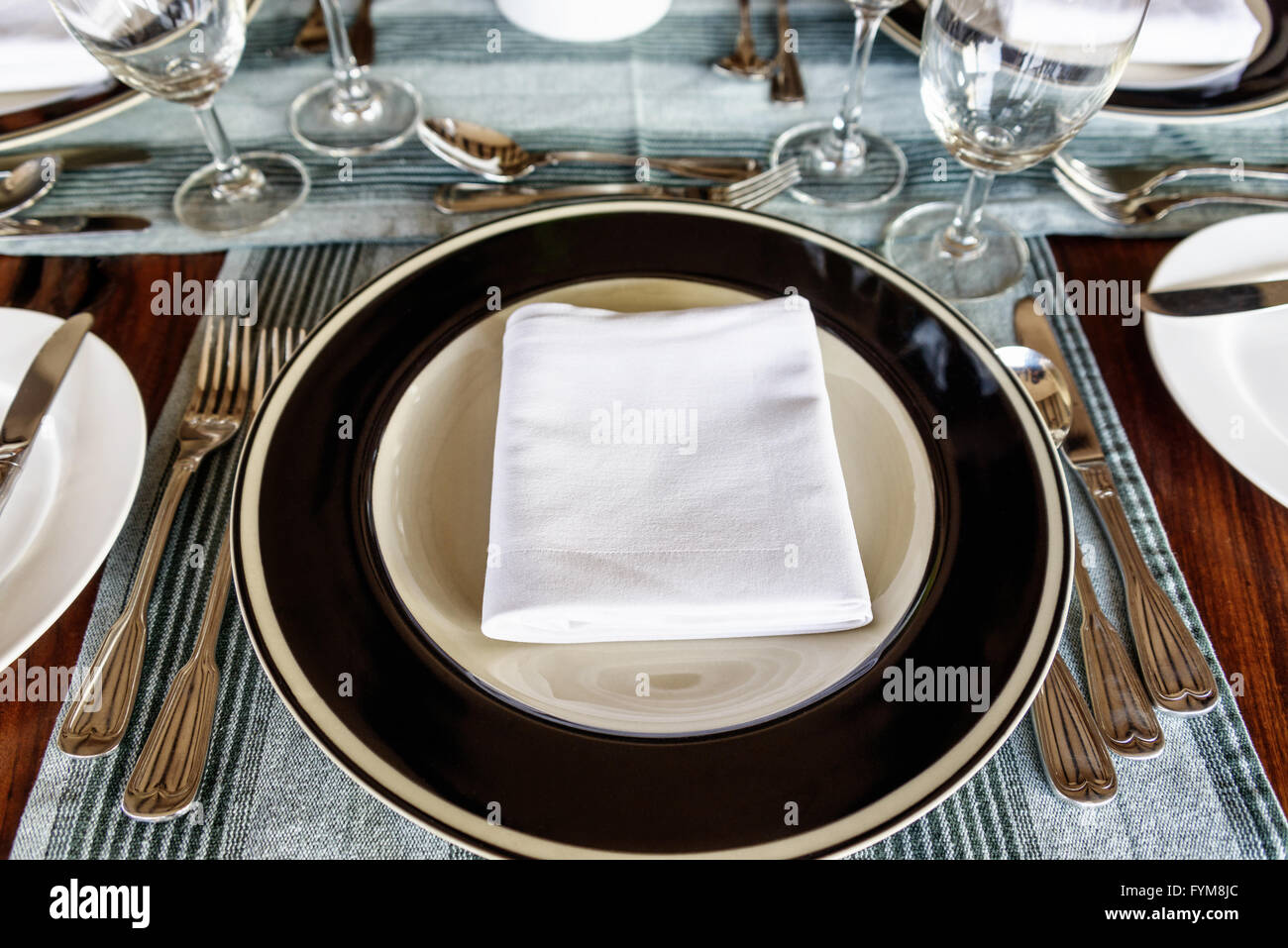 Vue perspective de la première personne sont soigneusement disposées sur une table à manger avec une serviette pliée au milieu de la plaque avec des ustensiles sur sid Banque D'Images