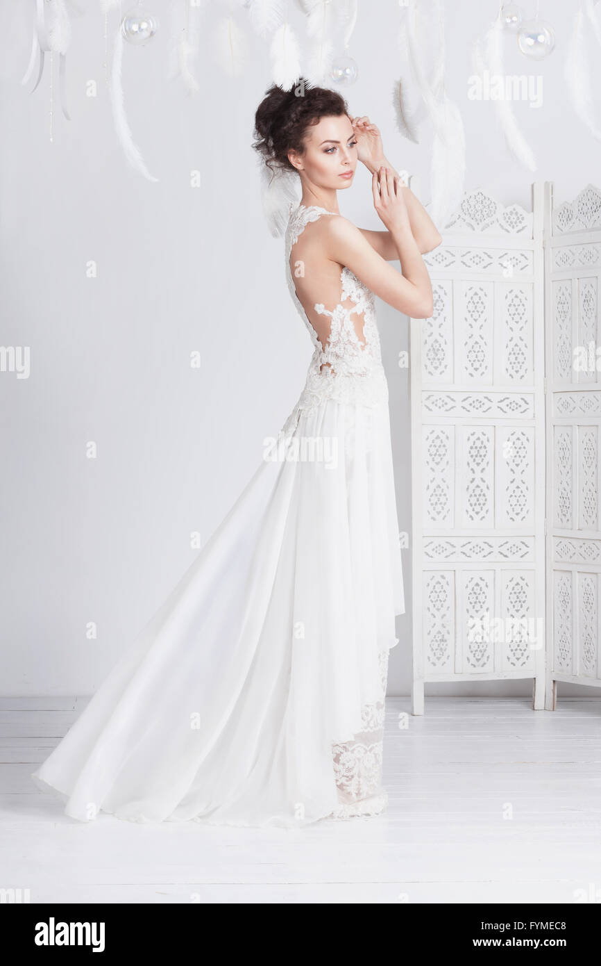 Grande et mince jeune mariée dans une luxueuse dentelle robe de mariage. Elle a une belle peau bronzée. La robe est translucide et a un Banque D'Images