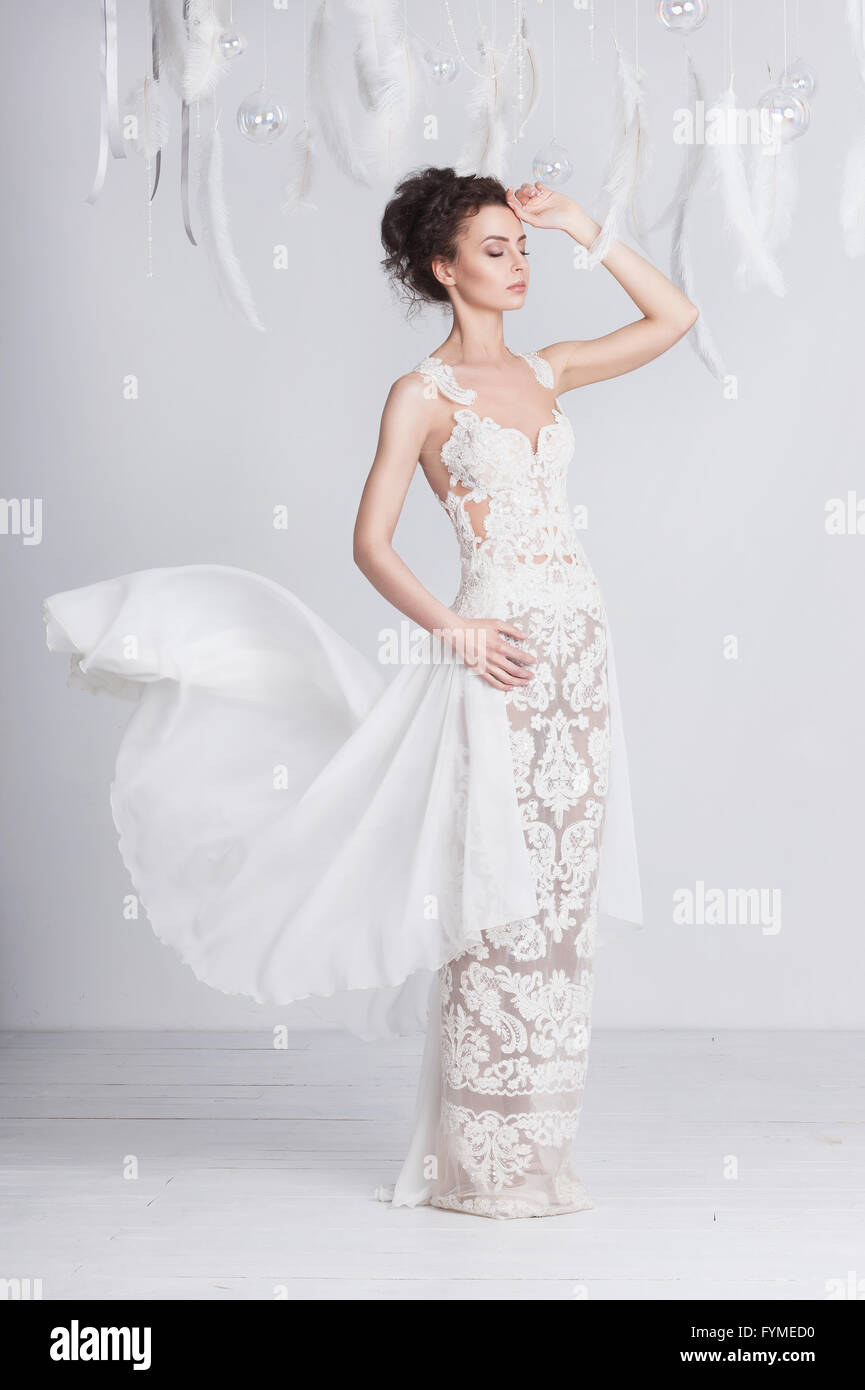 Grande et mince jeune mariée dans une robe en dentelle de luxe. Elle a une belle peau bronzée. La robe est translucide et dispose d'un s Banque D'Images