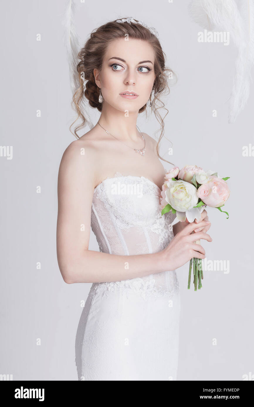 Portrait d'une jeune mariée et rêveuse dans une luxueuse dentelle robe de mariage. Elle a de beaux cheveux blond foncé, de grands yeux bleus et p Banque D'Images