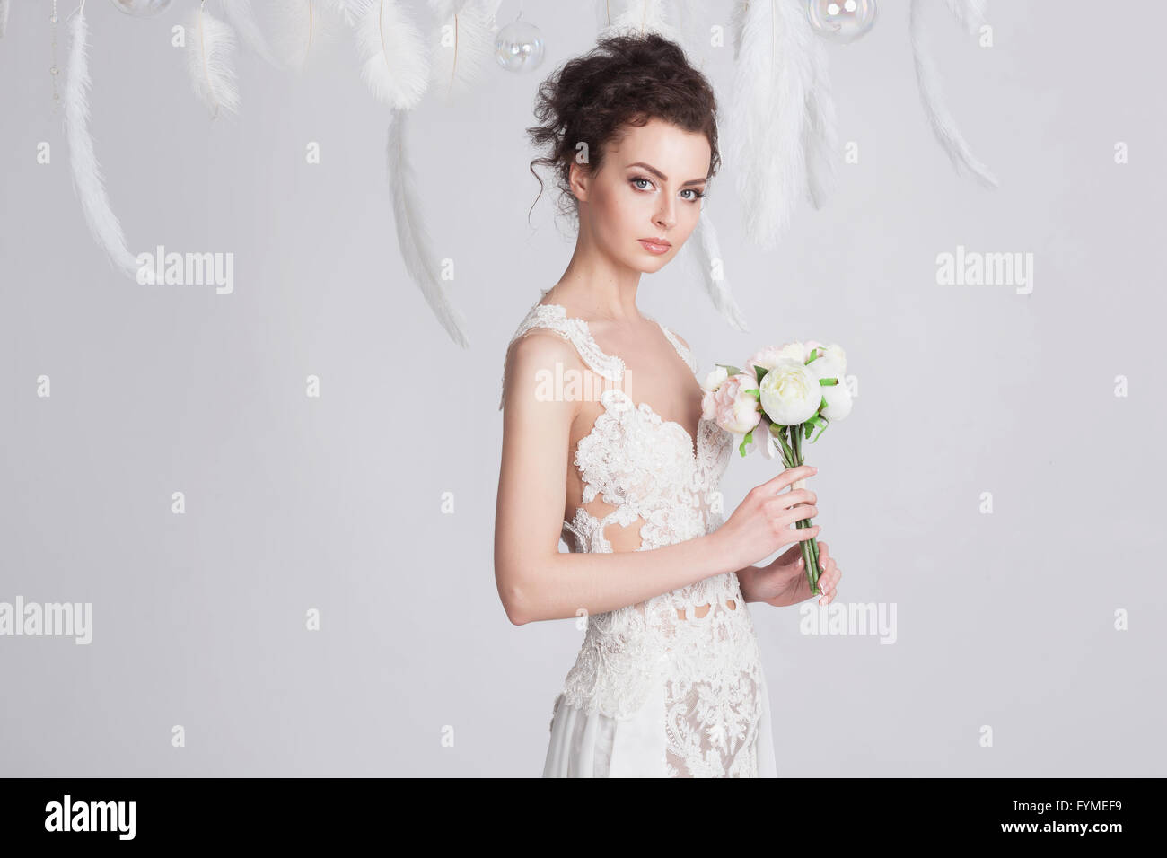 Portrait du jeune brun promise dans une dentelle luxueuse robe de mariage. Elle a une belle peau bronzée. La robe est translu Banque D'Images