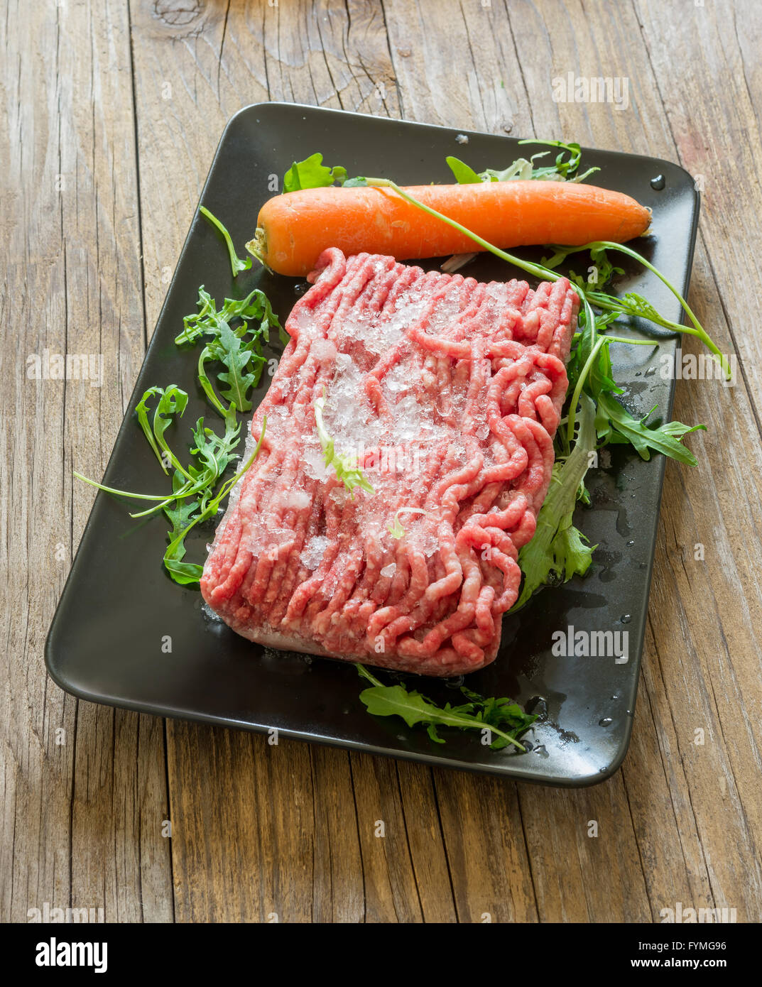 Boeuf haché congelé dans en polystyrène sur bois Banque D'Images