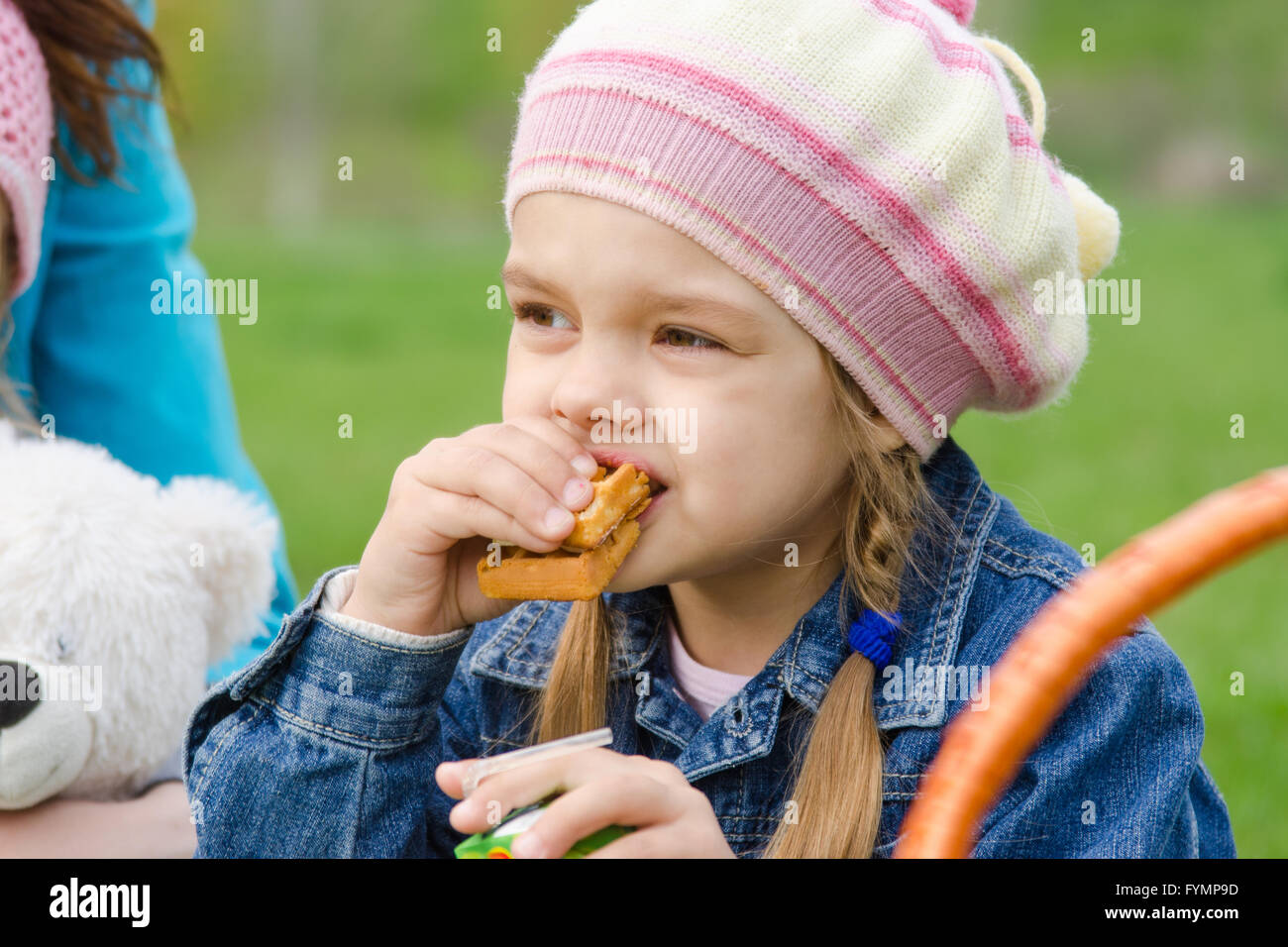 Girl eating cake à un pique-nique Banque D'Images