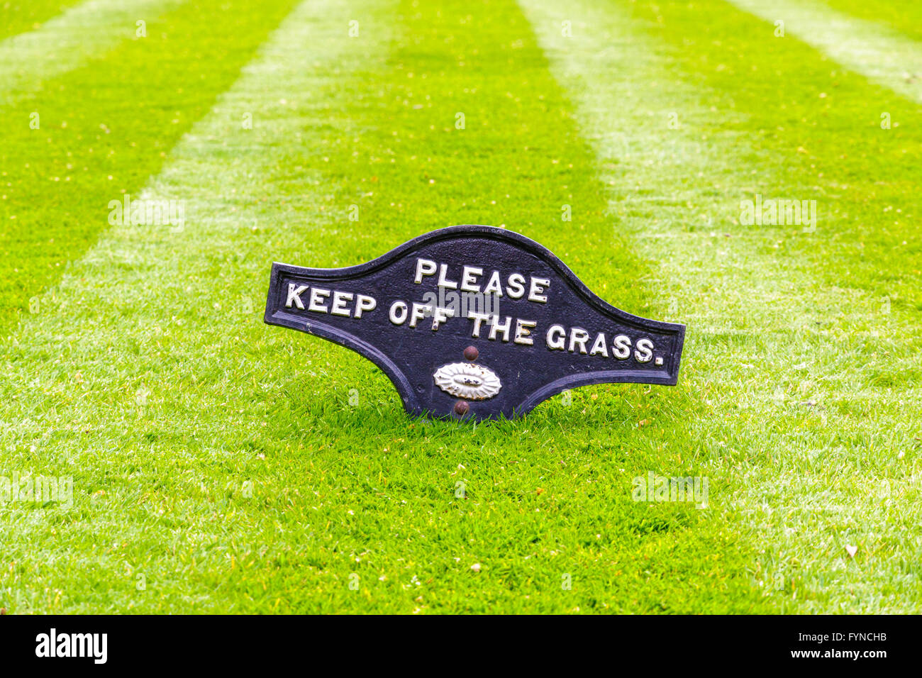 Un beau vert jardin pelouse qui vient d'être tondu un signe de ne pas marcher sur l'herbe Banque D'Images