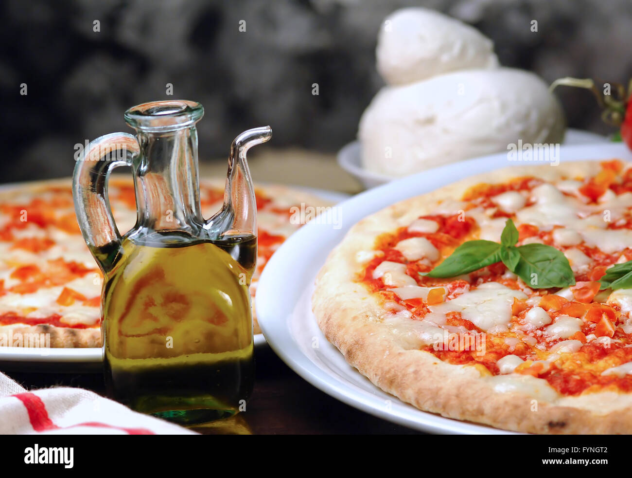 La tomate et mozzarella pizza à l'huile d'olive bouteille sur la table Banque D'Images