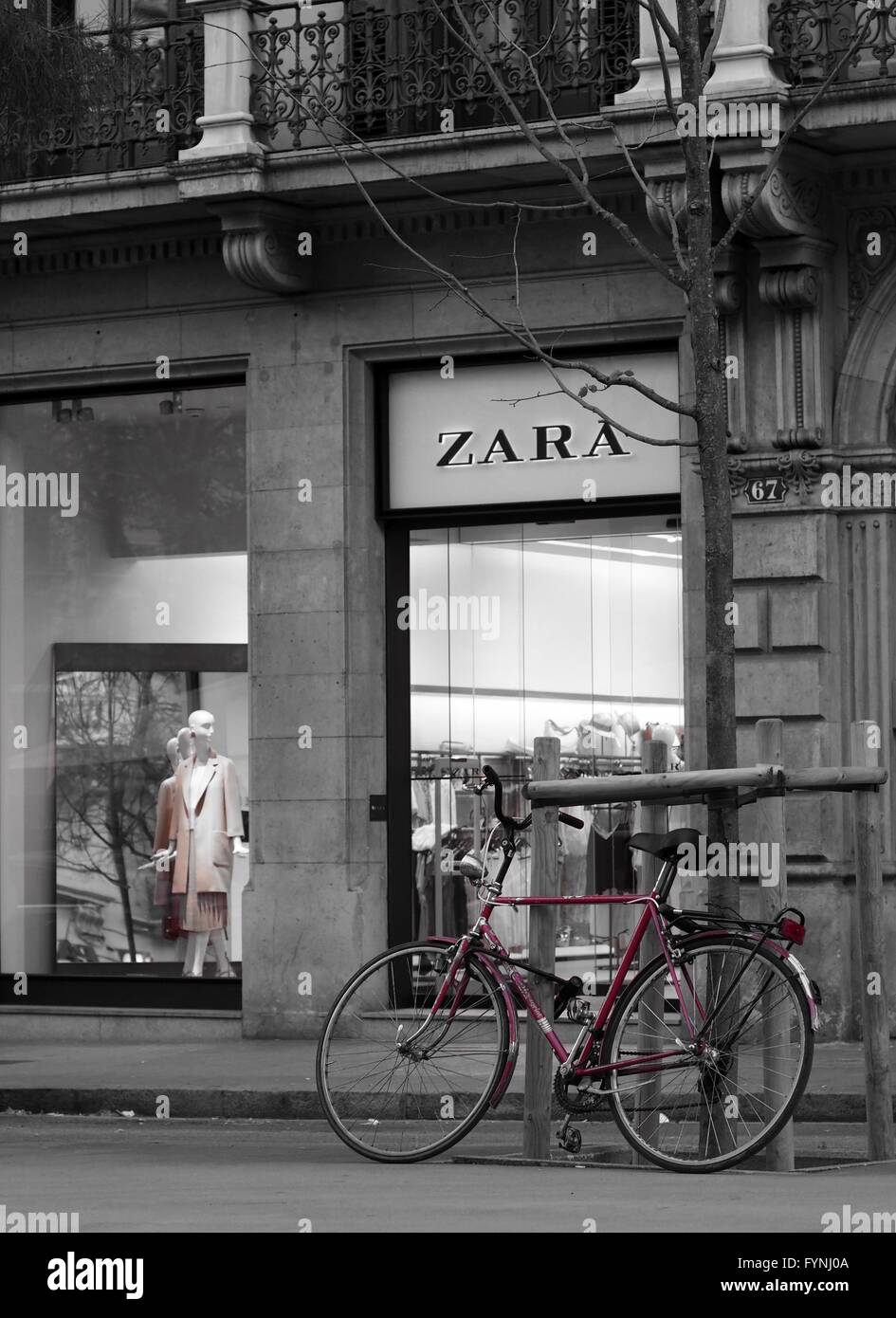 Mono image d'un vélo rouge à l'extérieur de magasin de vêtements Zara, des mannequins à out Banque D'Images