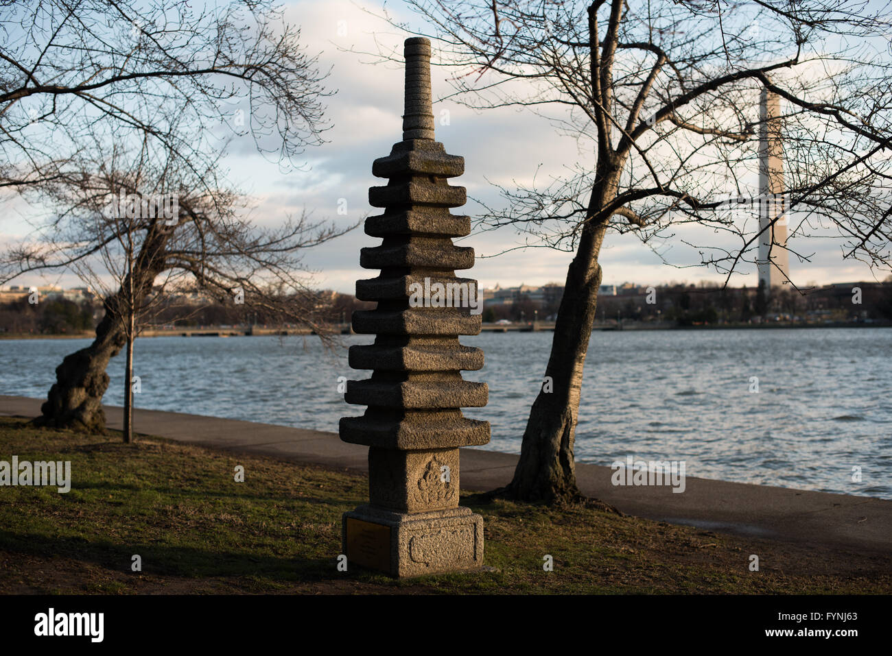 WASHINGTON DC — les cerisiers dormants et la pagode japonaise historique se dressent le long du Tidal Basin avant la saison de floraison printanière. La pagode de pierre était un cadeau de la ville de Yokohama, au Japon, en 1957, complétant les cerisiers offerts en 1912. Le Washington Monument est visible en arrière-plan à travers l'eau. Banque D'Images