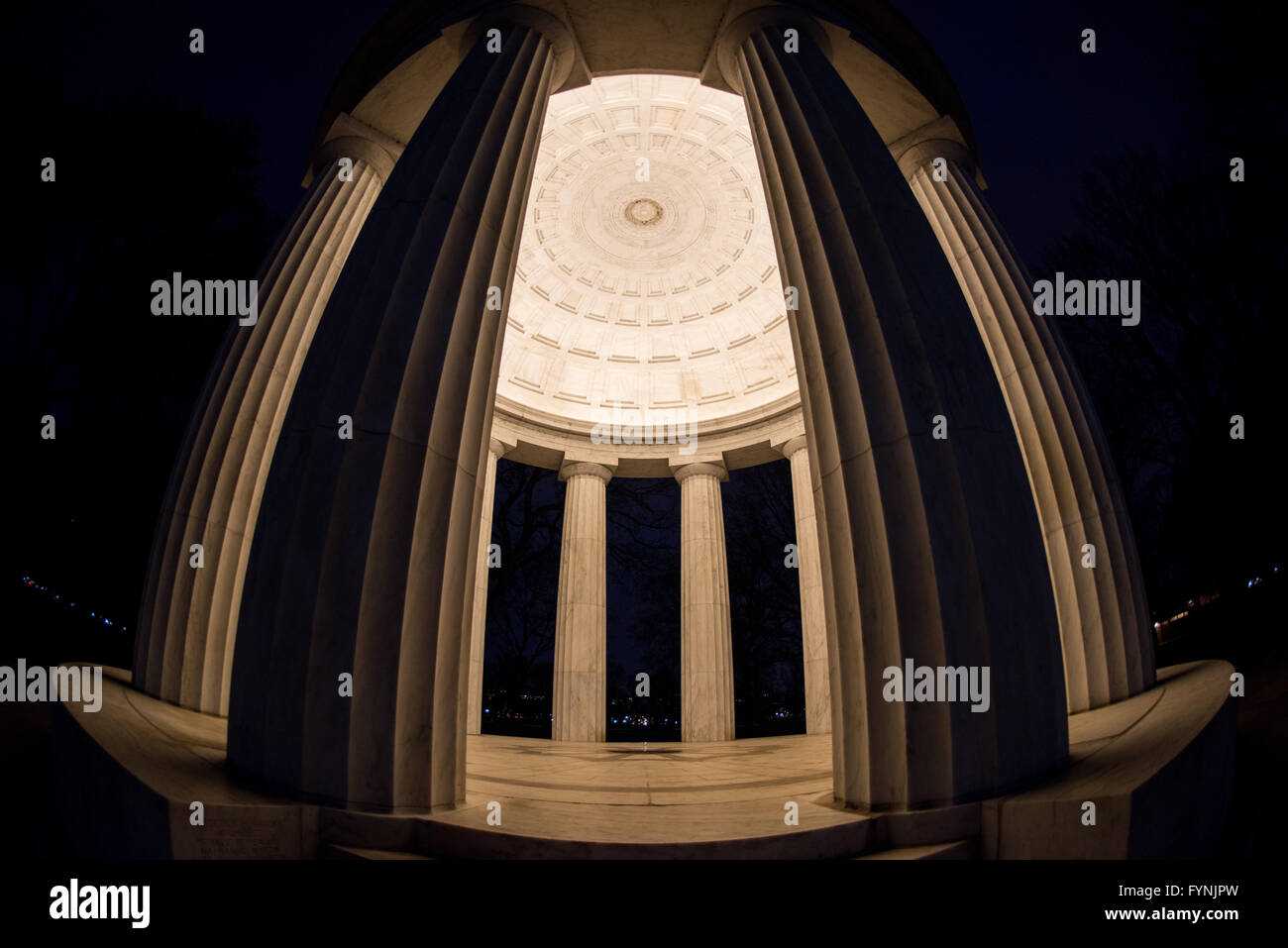 District of Columbia War Memorial Dome Interior Washington DC // WASHINGTON DC — vue intérieure du plafond et des colonnes du District of Columbia War Memorial la nuit sur le National Mall. Le mémorial circulaire, achevé en 1931, présente une construction en marbre du Vermont avec douze colonnes doriques soutenant le dôme illuminé. Cette perspective grand angle met en valeur les détails architecturaux classiques de la structure intérieure du mémorial. Banque D'Images