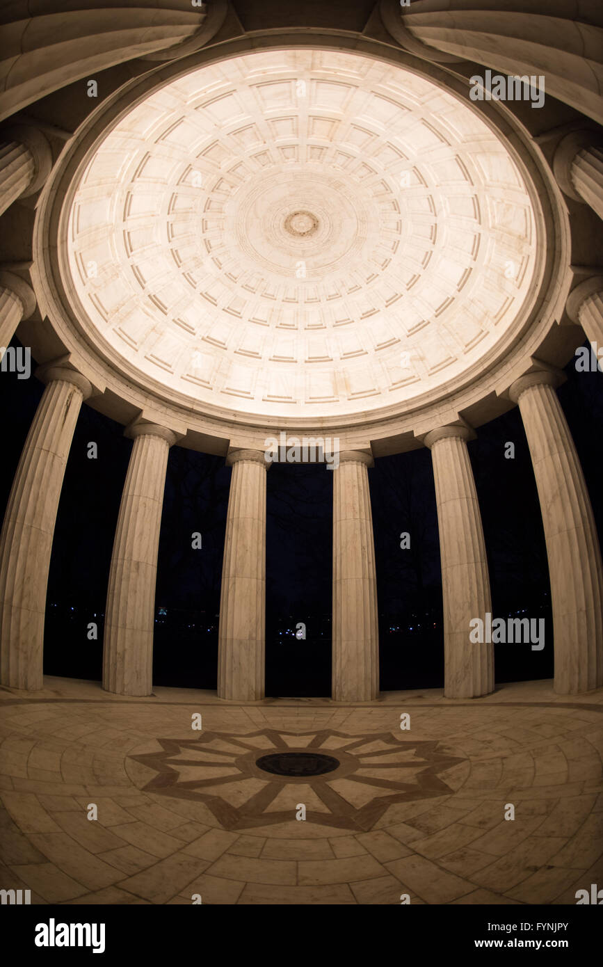 WASHINGTON DC, États-Unis — vue intérieure du plafond et des colonnes du monument commémoratif de la guerre du district de Columbia la nuit sur le National Mall. Le mémorial circulaire, achevé en 1931, présente une construction en marbre du Vermont avec douze colonnes doriques soutenant le dôme illuminé. Cette perspective grand angle met en valeur les détails architecturaux classiques de la structure intérieure du mémorial. Banque D'Images