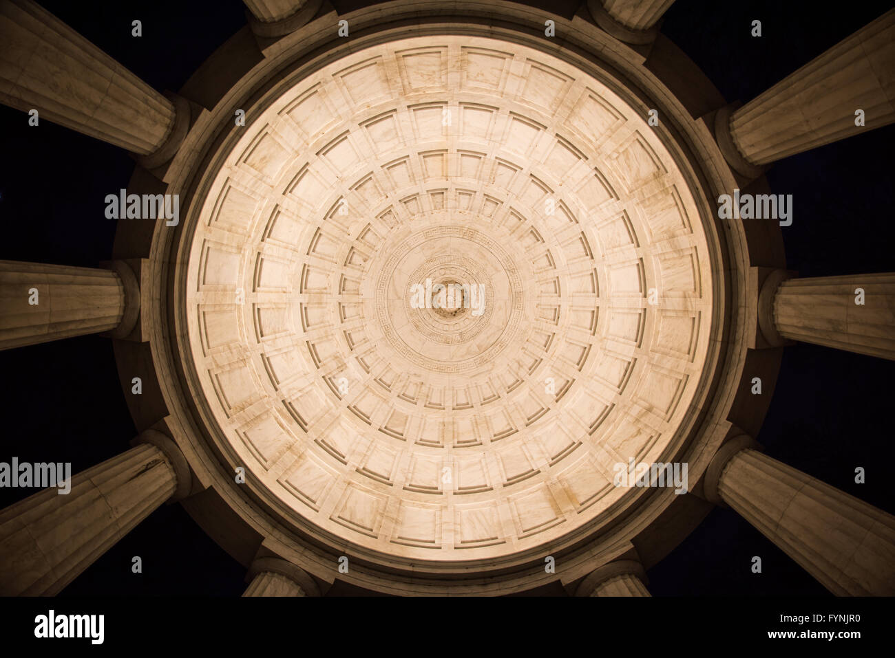 WASHINGTON DC, États-Unis — vue intérieure du plafond et des colonnes du monument commémoratif de la guerre du district de Columbia la nuit sur le National Mall. Le mémorial circulaire, achevé en 1931, présente une construction en marbre du Vermont avec douze colonnes doriques soutenant le dôme illuminé. Cette perspective grand angle met en valeur les détails architecturaux classiques de la structure intérieure du mémorial. Banque D'Images