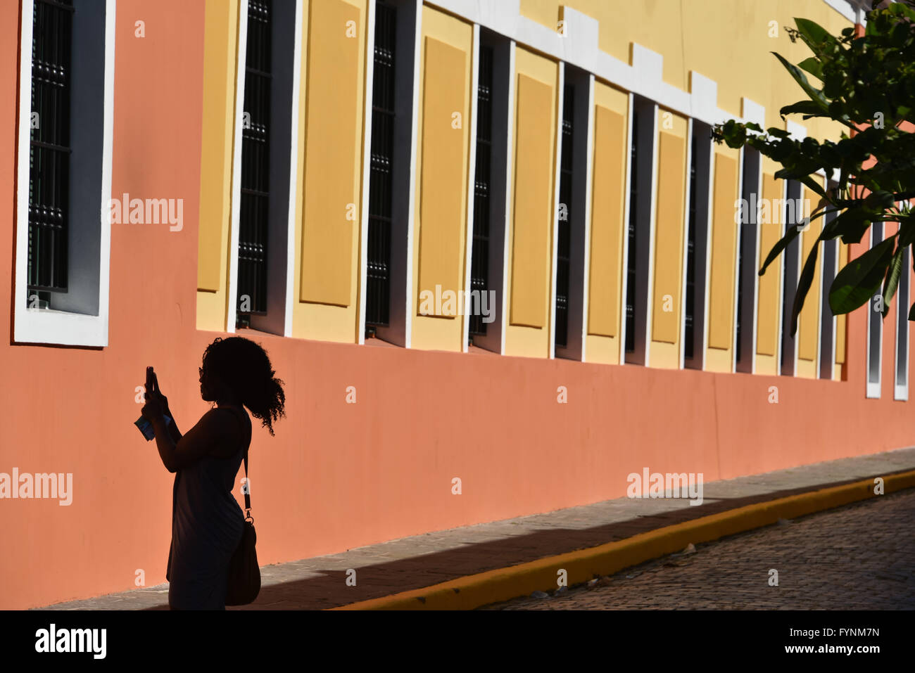 Silhouette d'un touriste prend une photo de bâtiments colorés dans le Vieux San Juan, Puerto Rico Banque D'Images